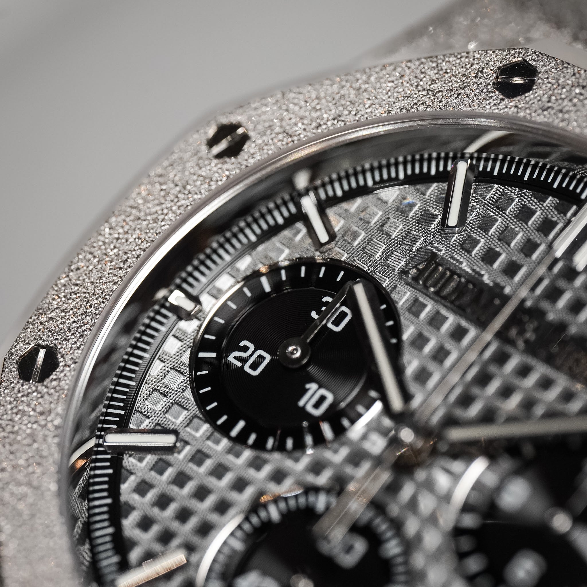 Close-up of a detailed silver watch with a black face
