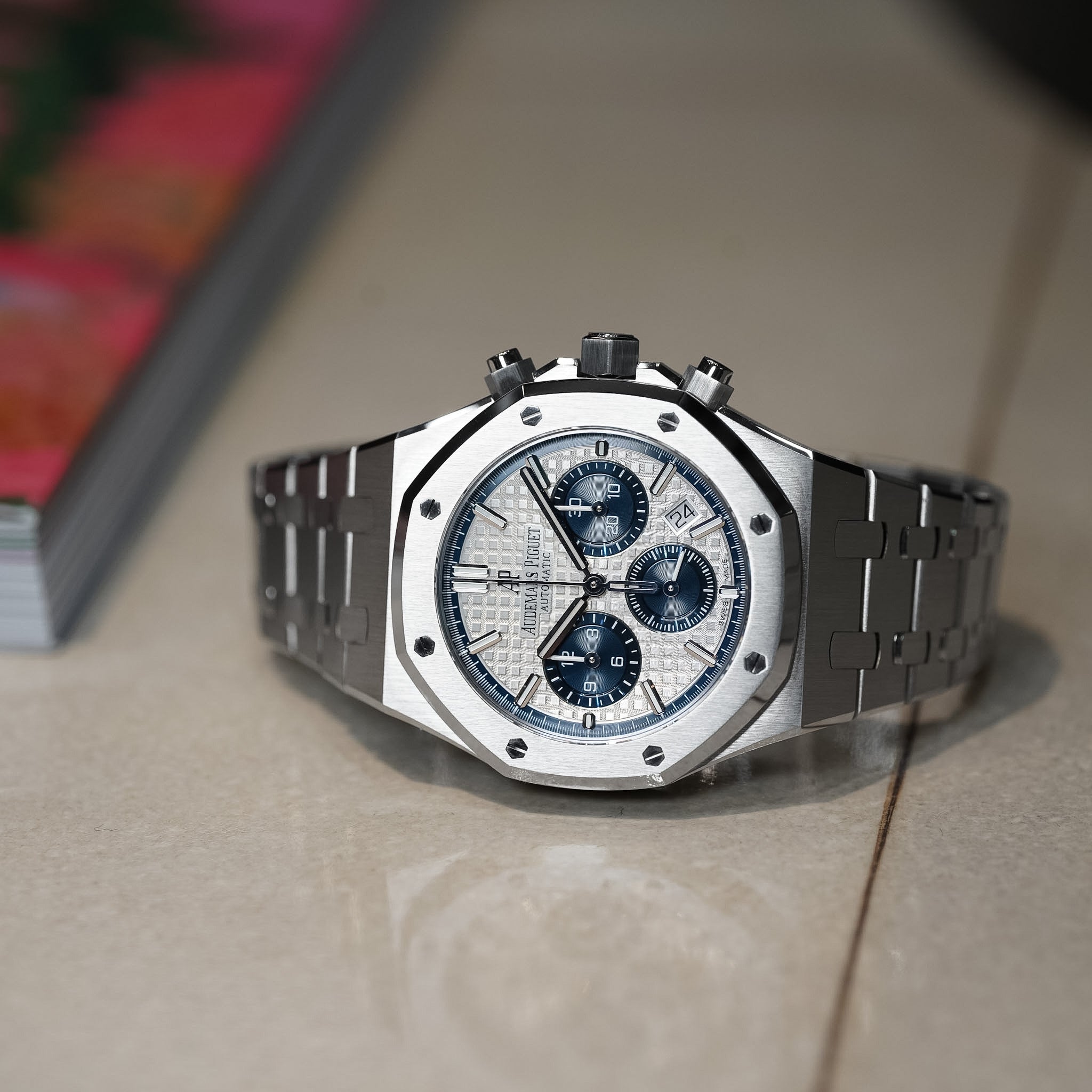 Luxury watch with a silver case and black strap on a light surface