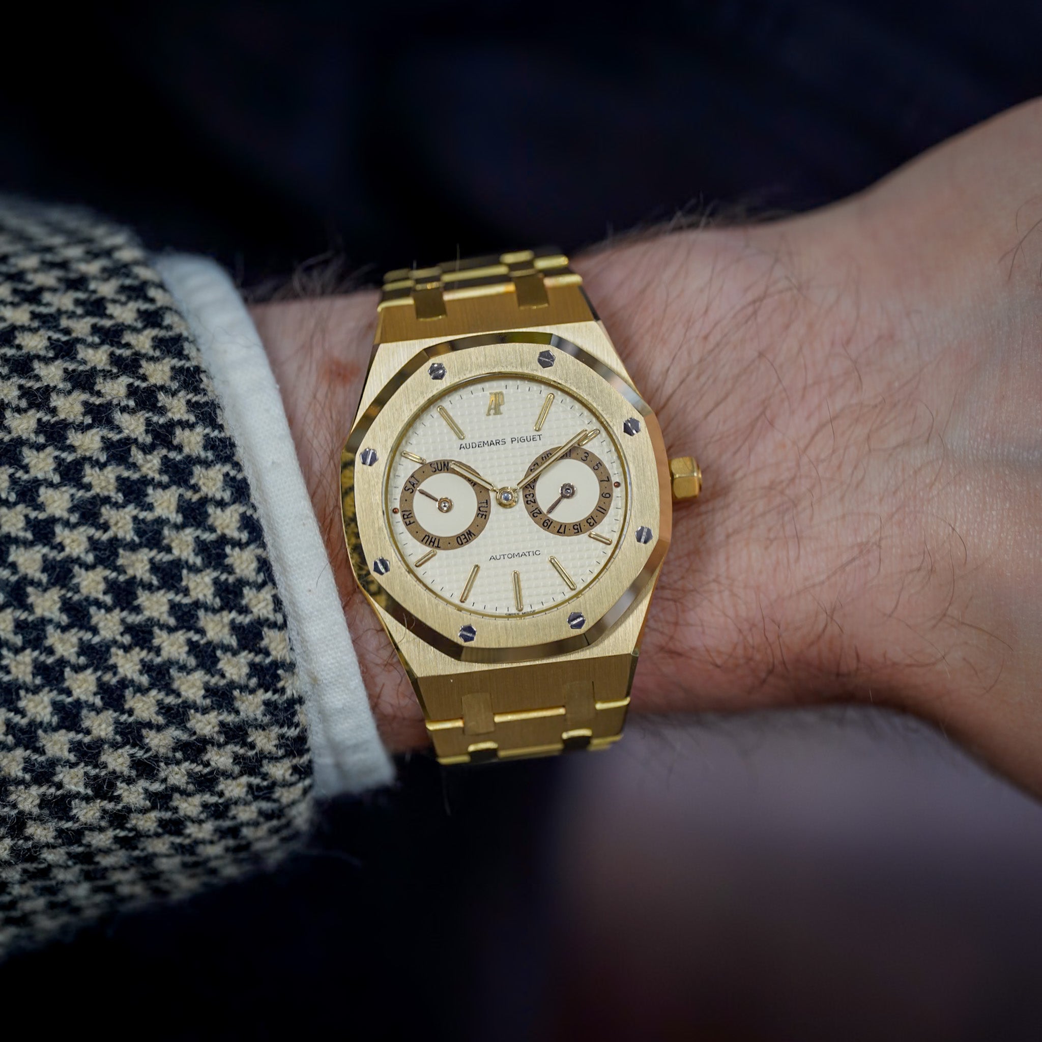 Gold wristwatch on a person's wrist with a blurred background