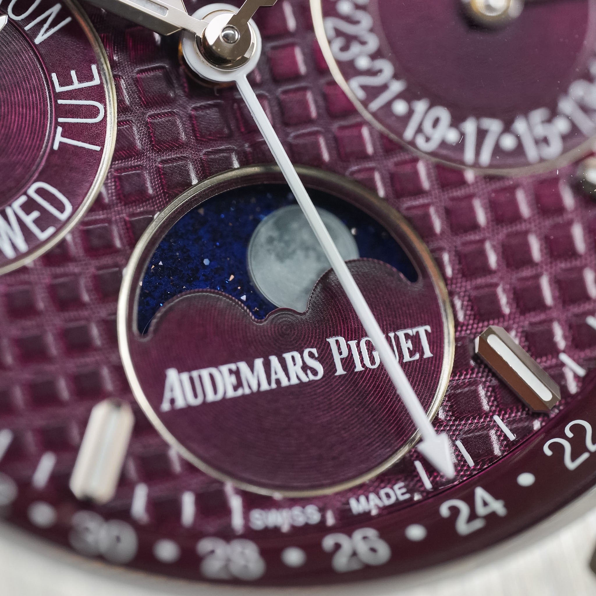 Close-up of a watch face with 'Audemars Piguet' branding and moon phase indicator.