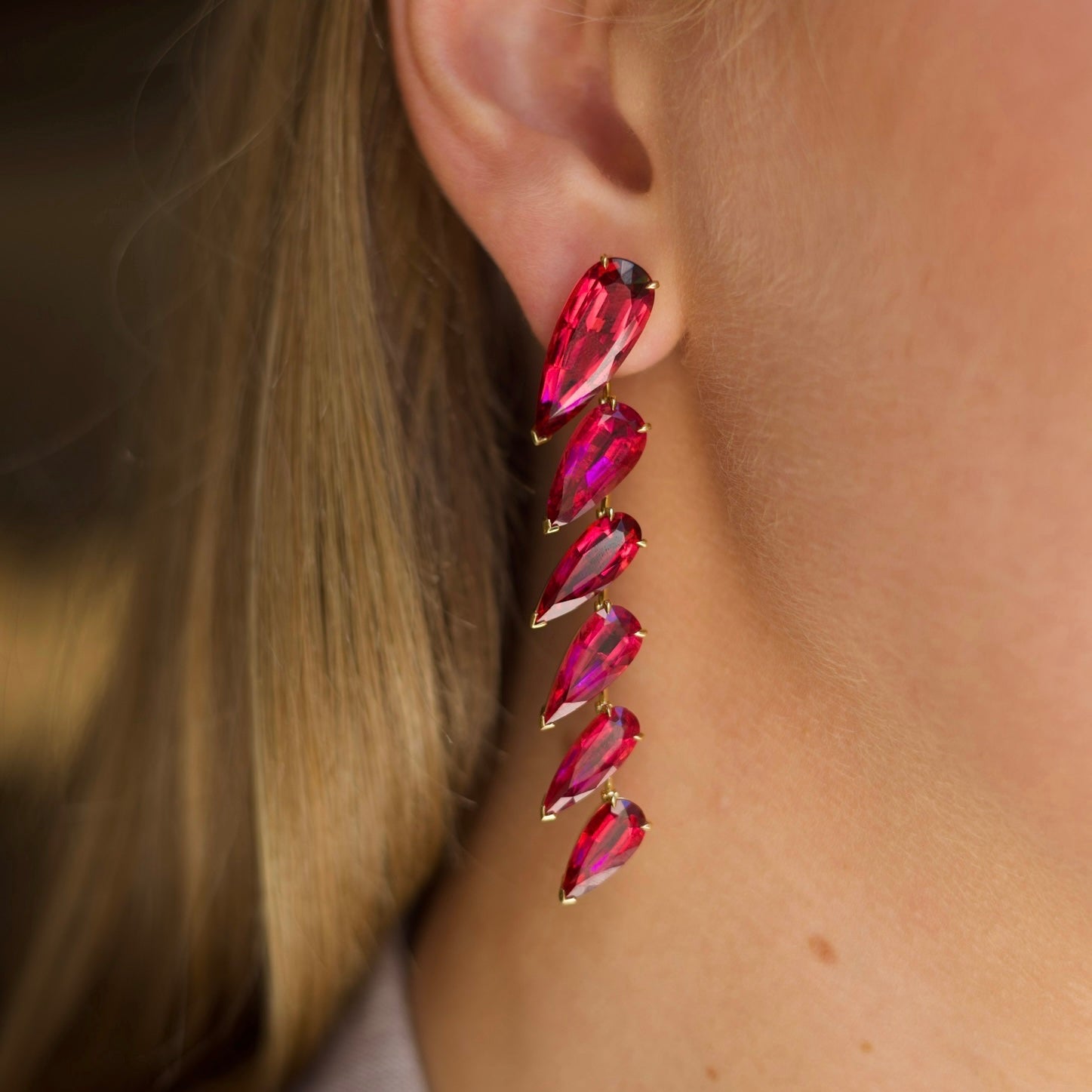 Pear Shape Rubellite Drop Earrings in 18K yellow gold, featuring twelve pear-shaped rubellites totaling 42.38 carats, post and butterfly closure on model.
