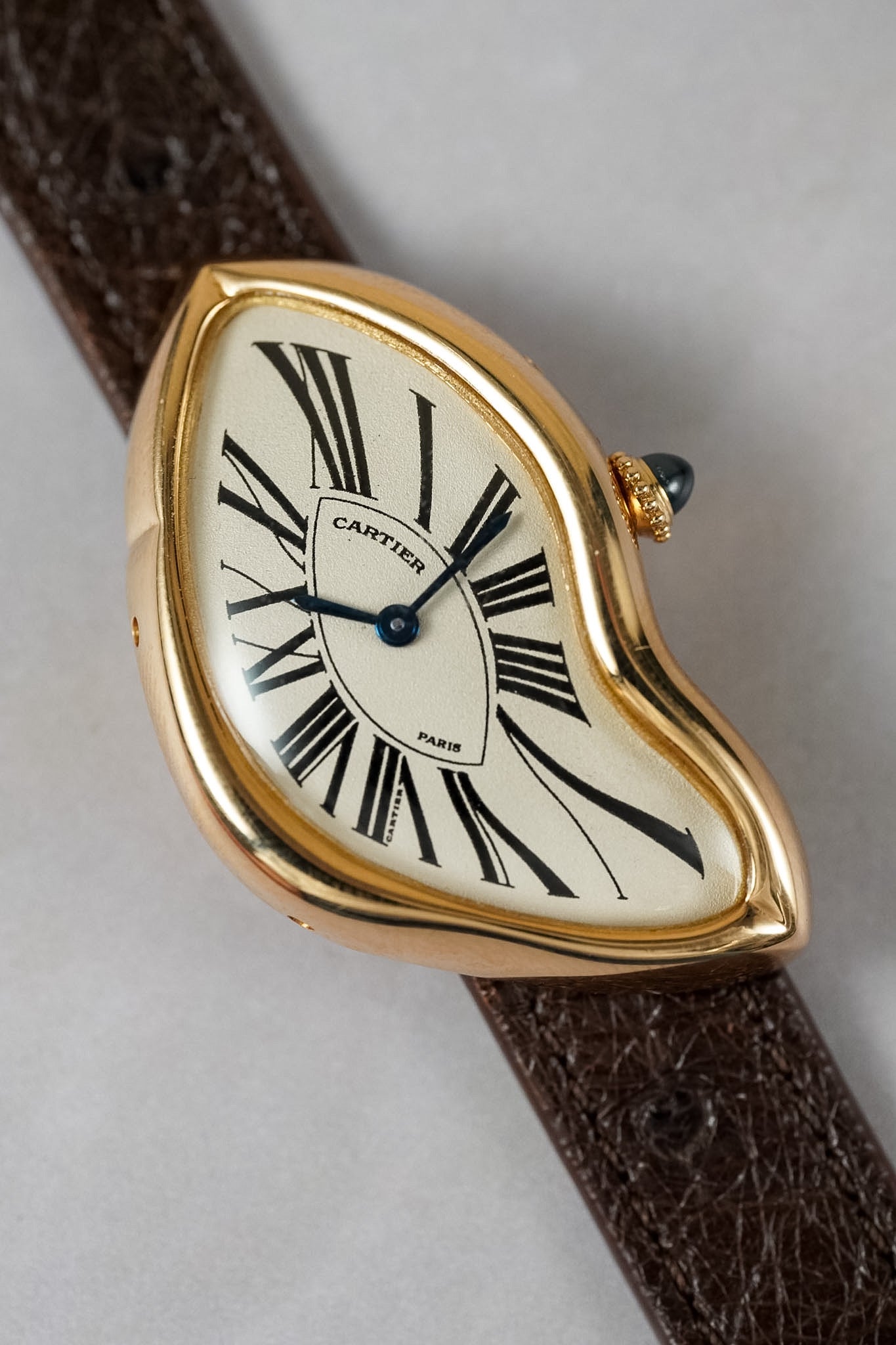 Closeup of a gold wristwatch against a white background