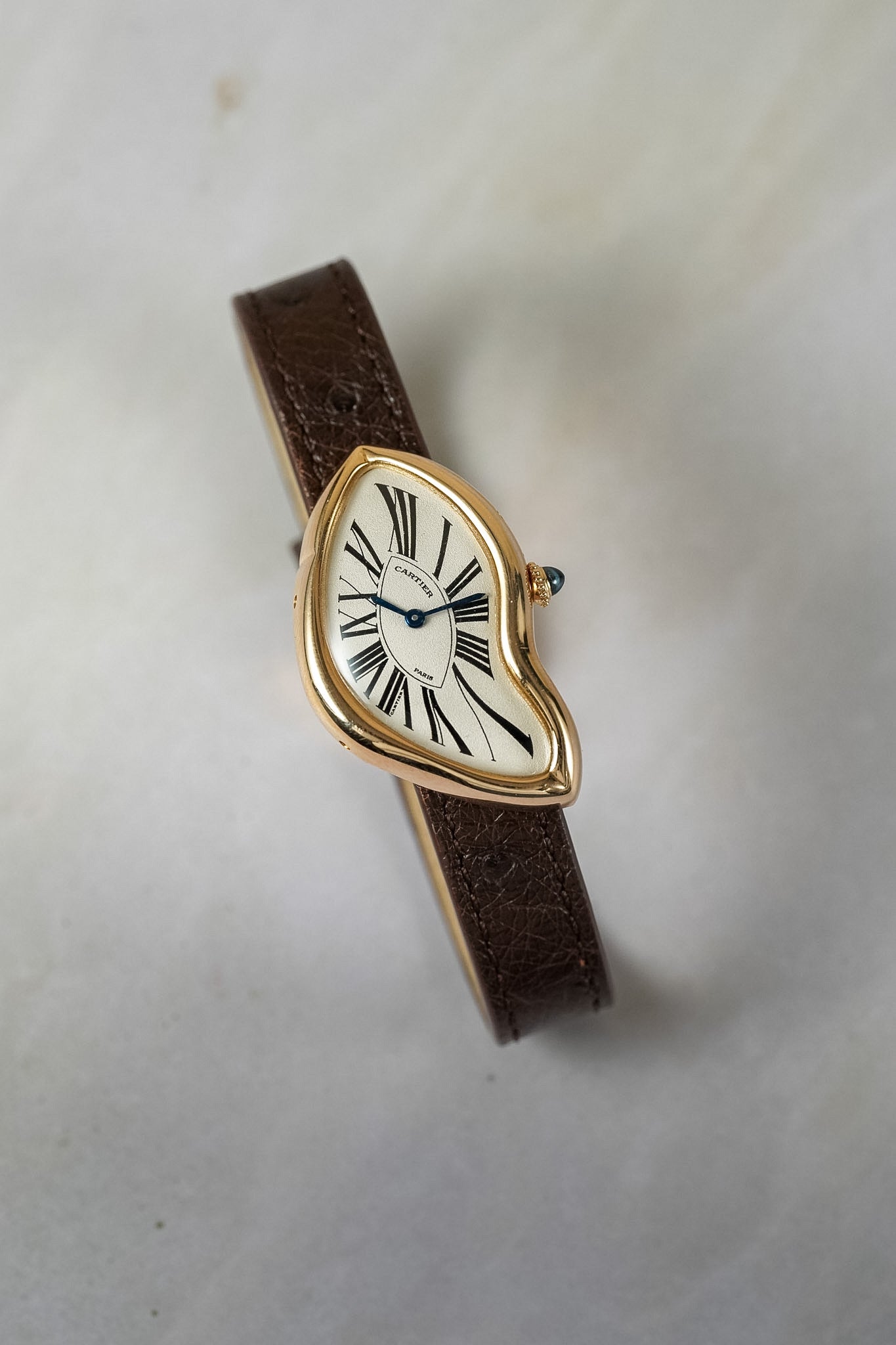 Gold watch with a white dial on a white background