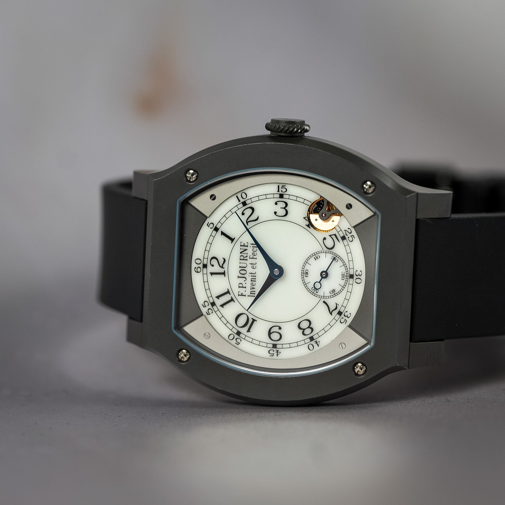 White dial F.P.Journe Elegante laying sideways on a gray table