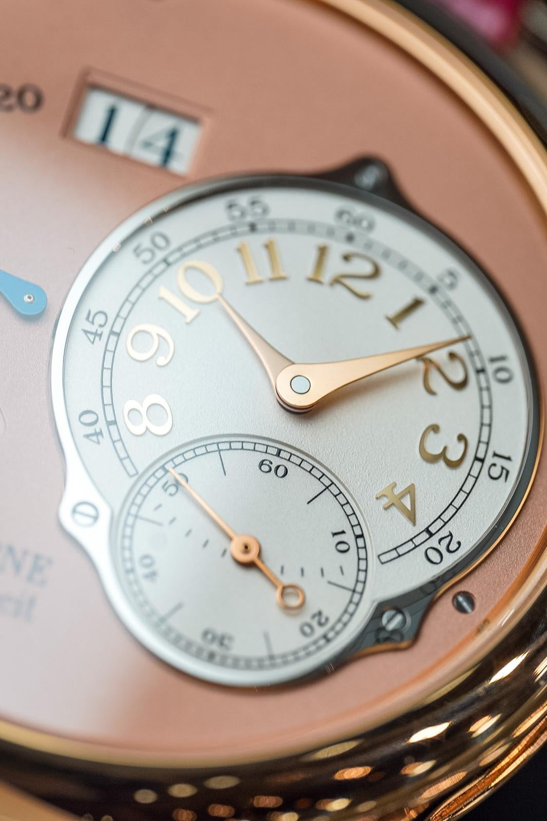 Close-up of a pocket watch with a detailed face and rose gold accents.