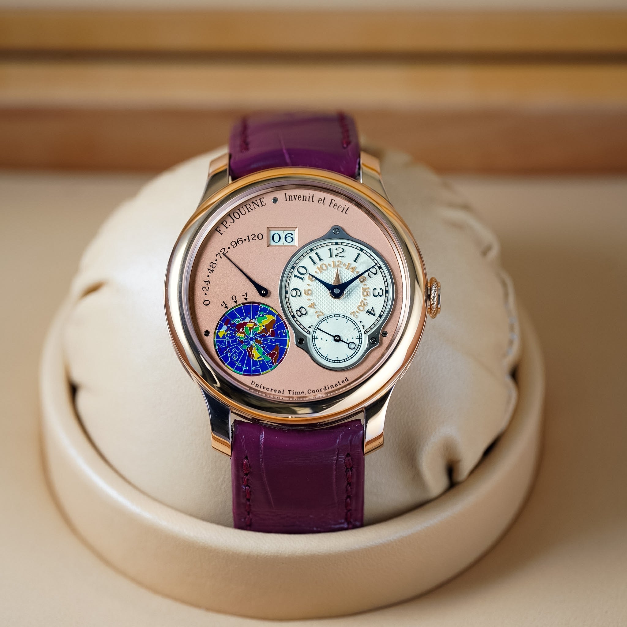 Luxury watch with purple strap on a beige cushion