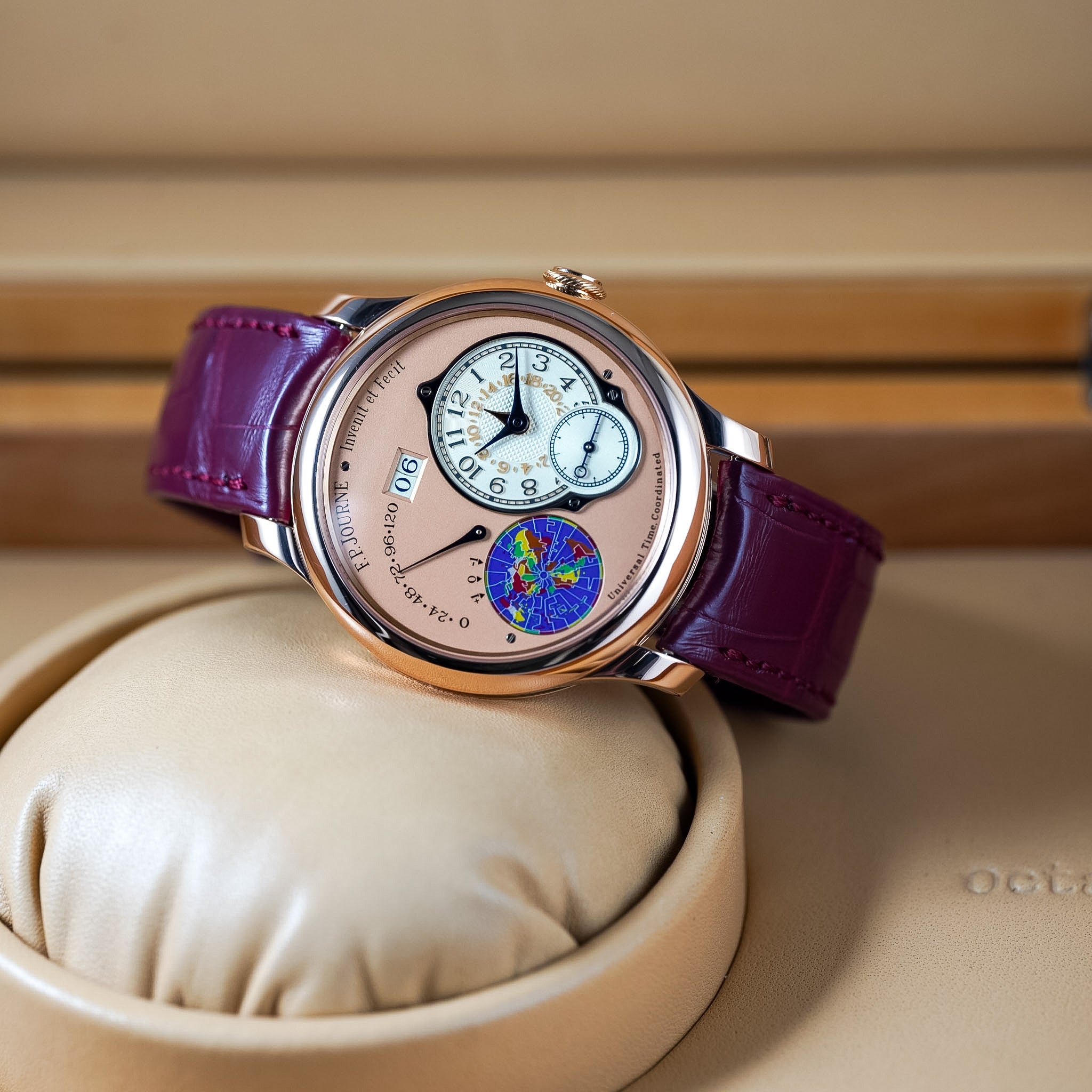 Luxury watch with a purple strap on a beige cushion