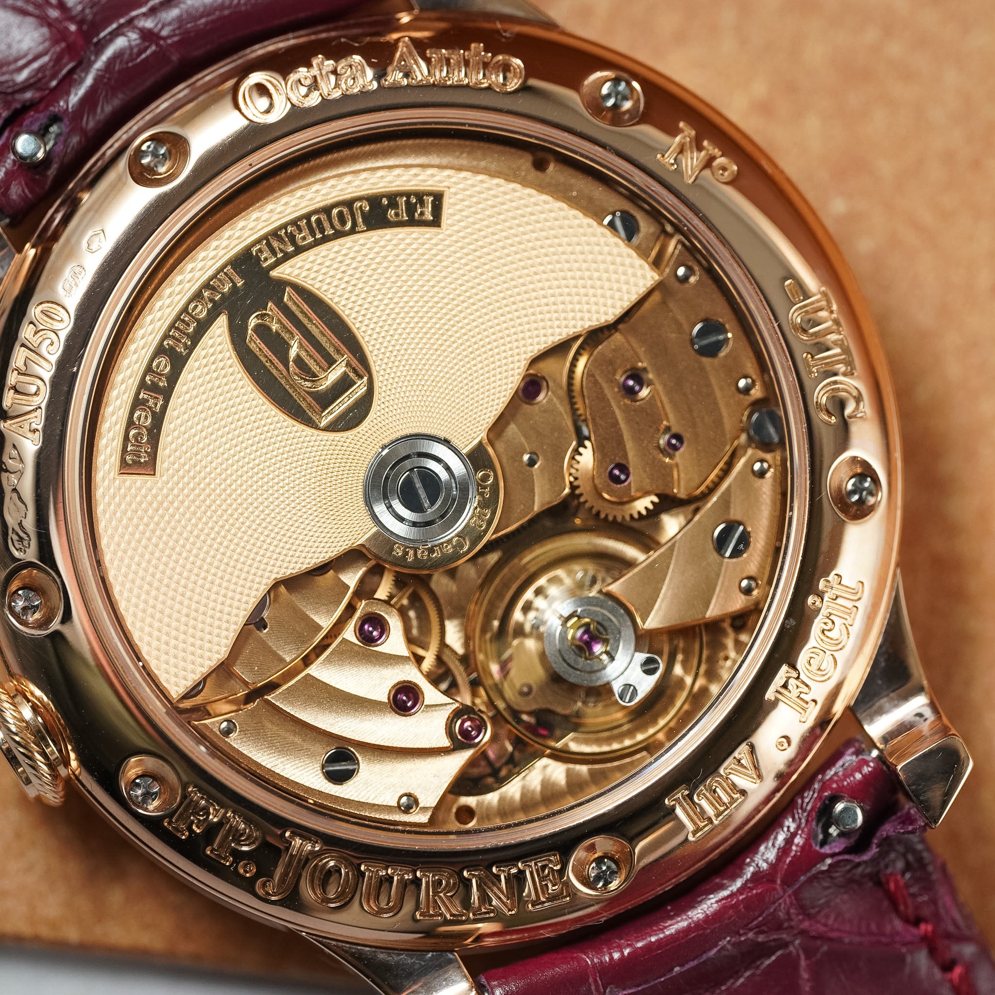 Close-up of a watch mechanism with visible branding on a brown background