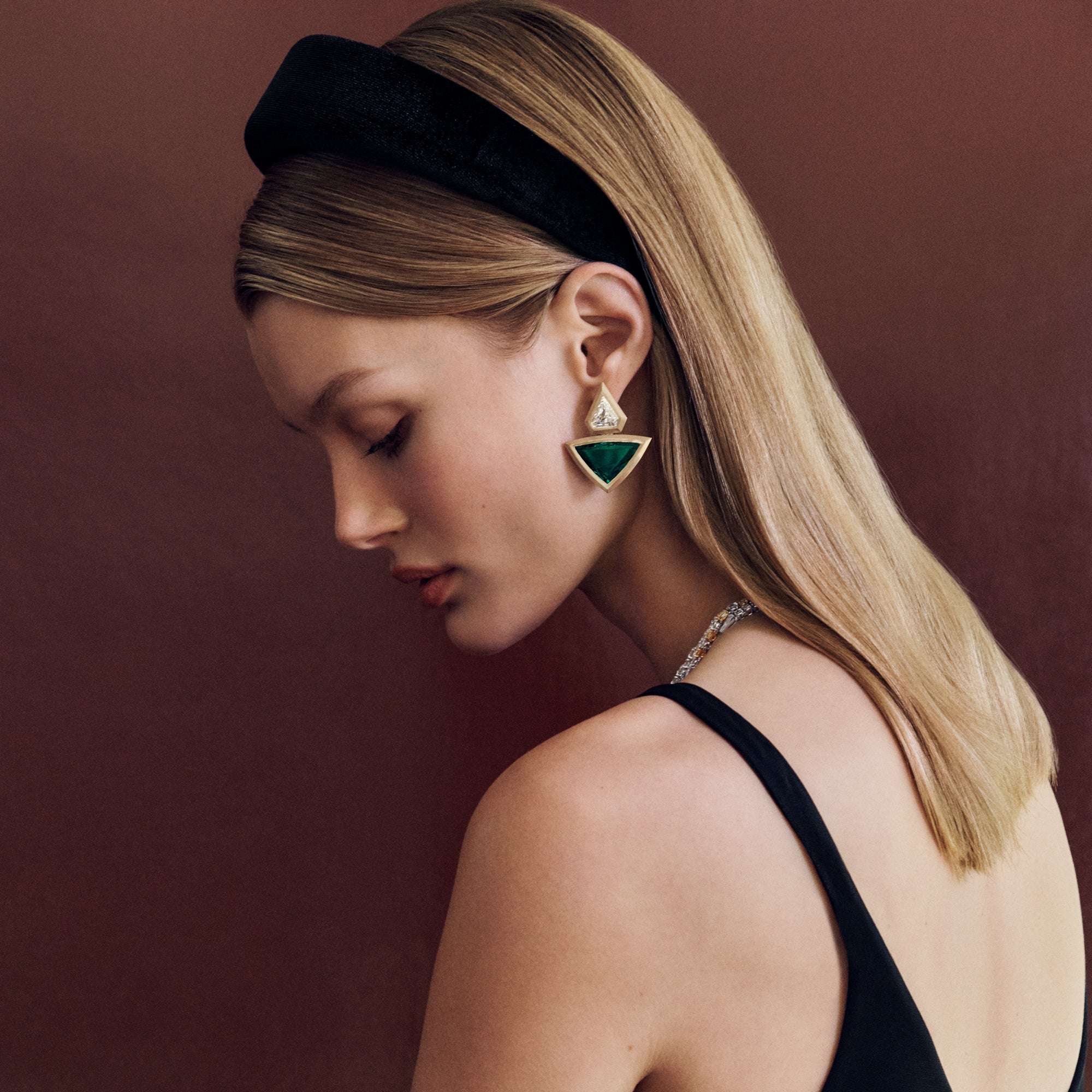 Trillion Emerald and Diamond Earrings in 18K yellow gold featuring Zambian emeralds and GIA-certified diamonds, photographed on model.