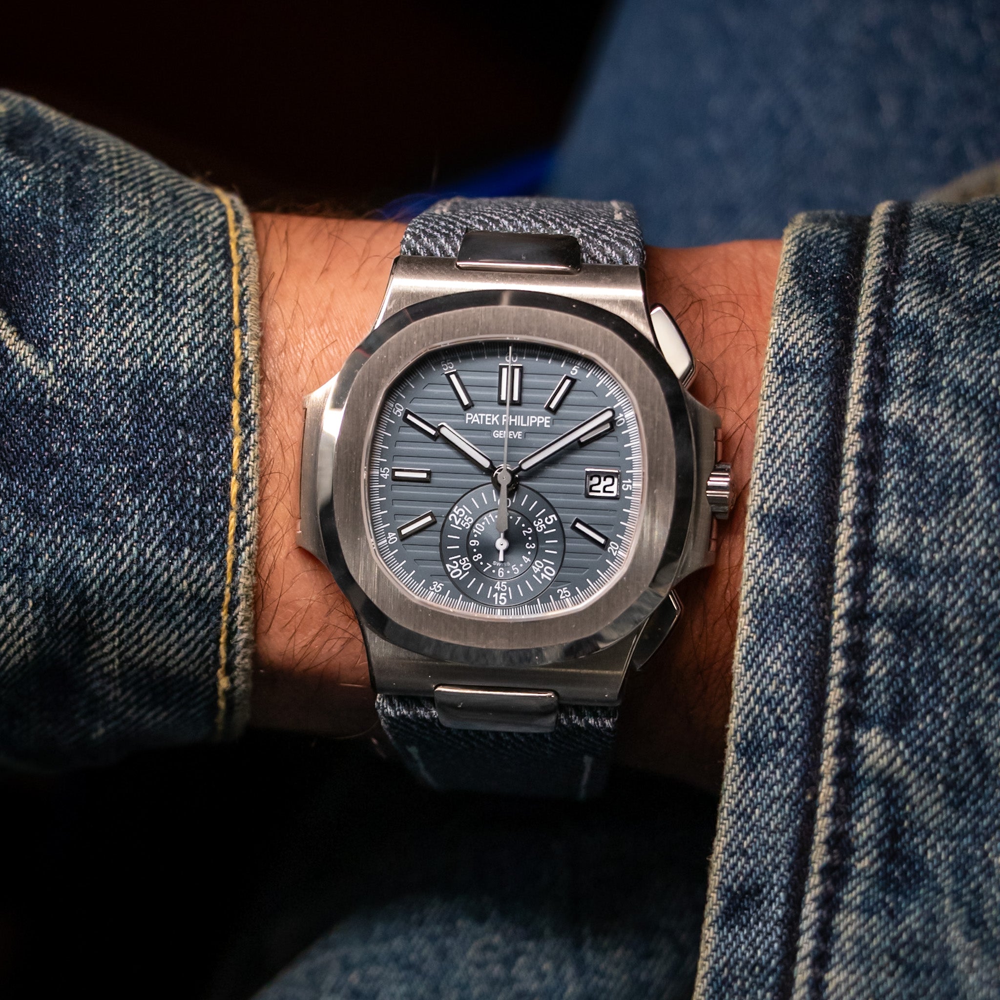 Blue dial watch on a model wearing a denim jacket