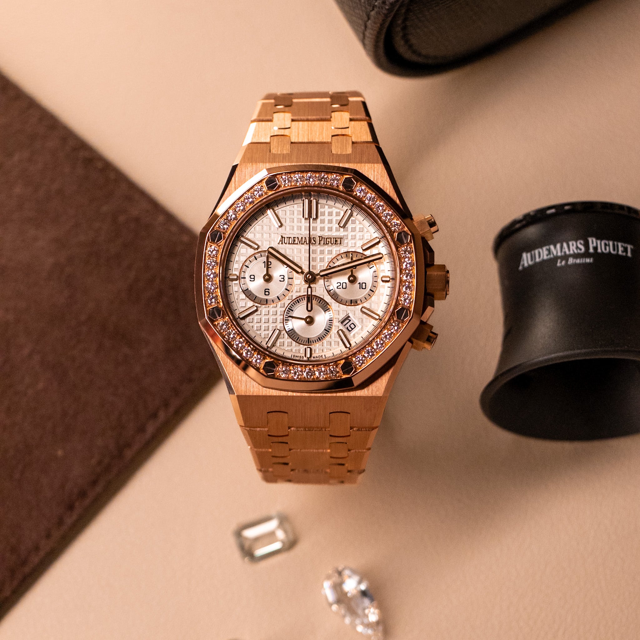 Audemars Piguet Royal Oak Chronograph 26715OR in 18k rose gold with diamond-set bezel, silver “Grande Tapisserie” dial, integrated rose gold bracelet with watch box and loose blurred diamond stones