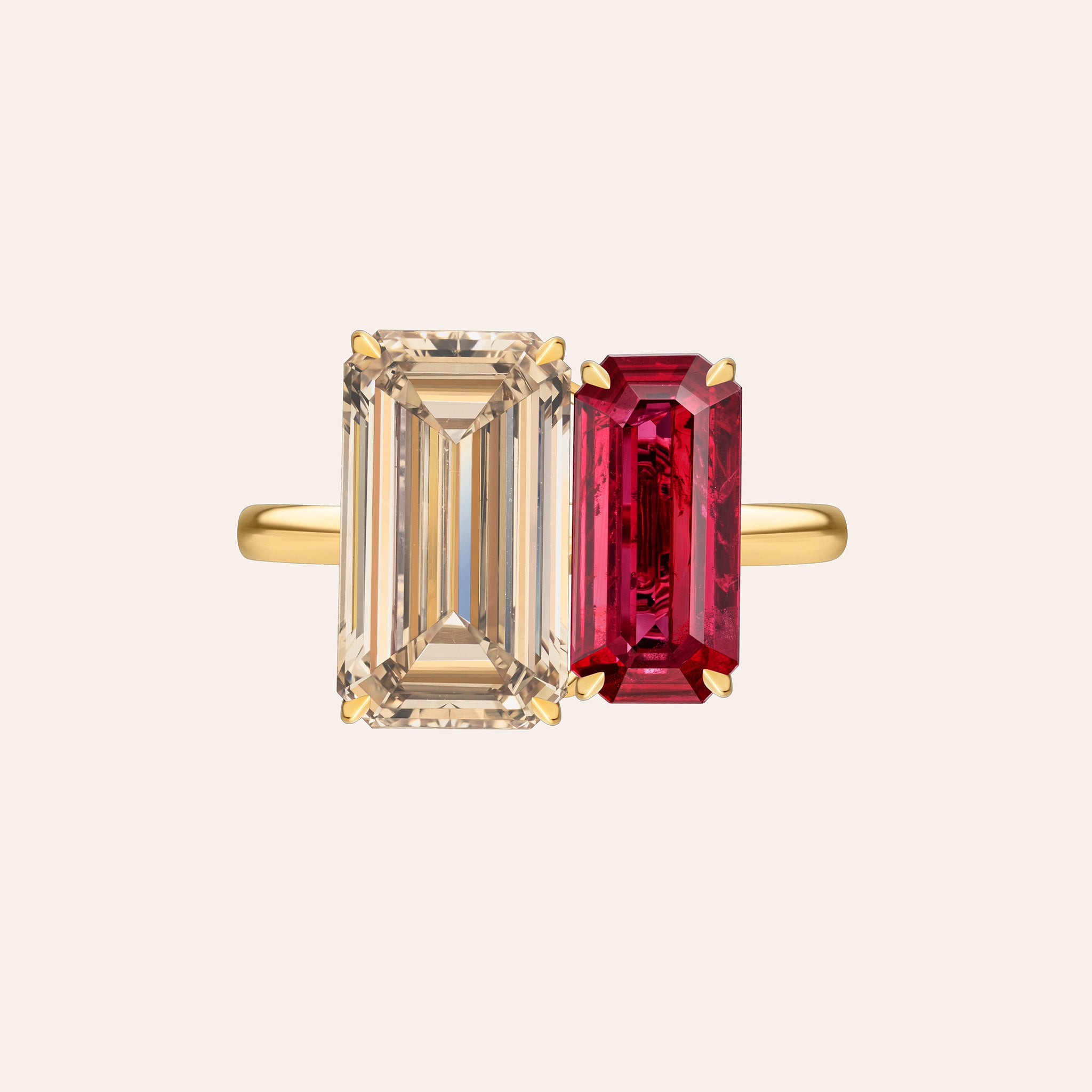 A1: Front view of an 18K yellow gold two-stone ring featuring a 4.01ct fancy yellow-brown emerald-cut diamond alongside a 2.56ct red ruby emerald cut, set in a toi et moi configuration with double corner prongs.