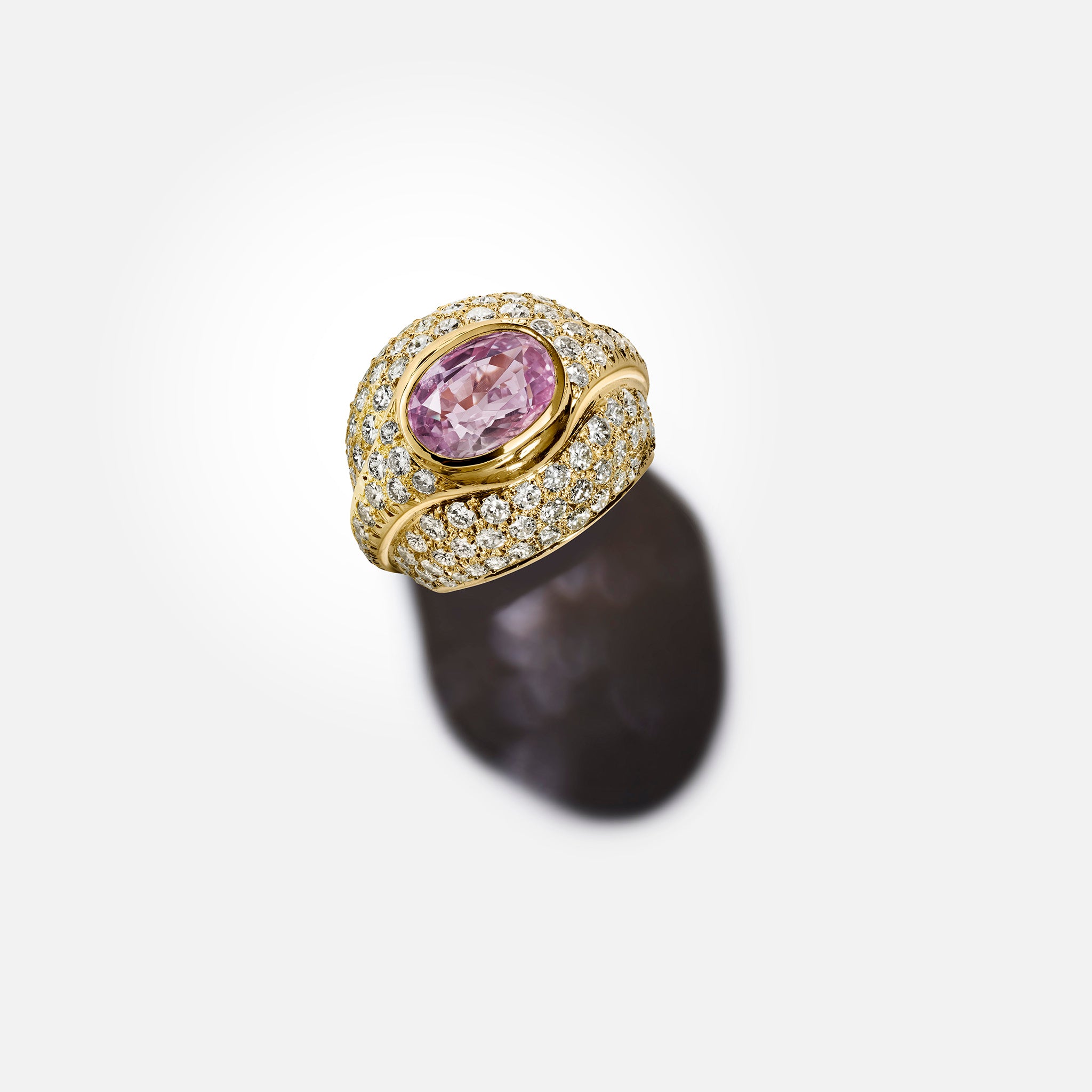 Vintage 18K yellow gold bombé ring with an oval pink sapphire and pavé diamonds