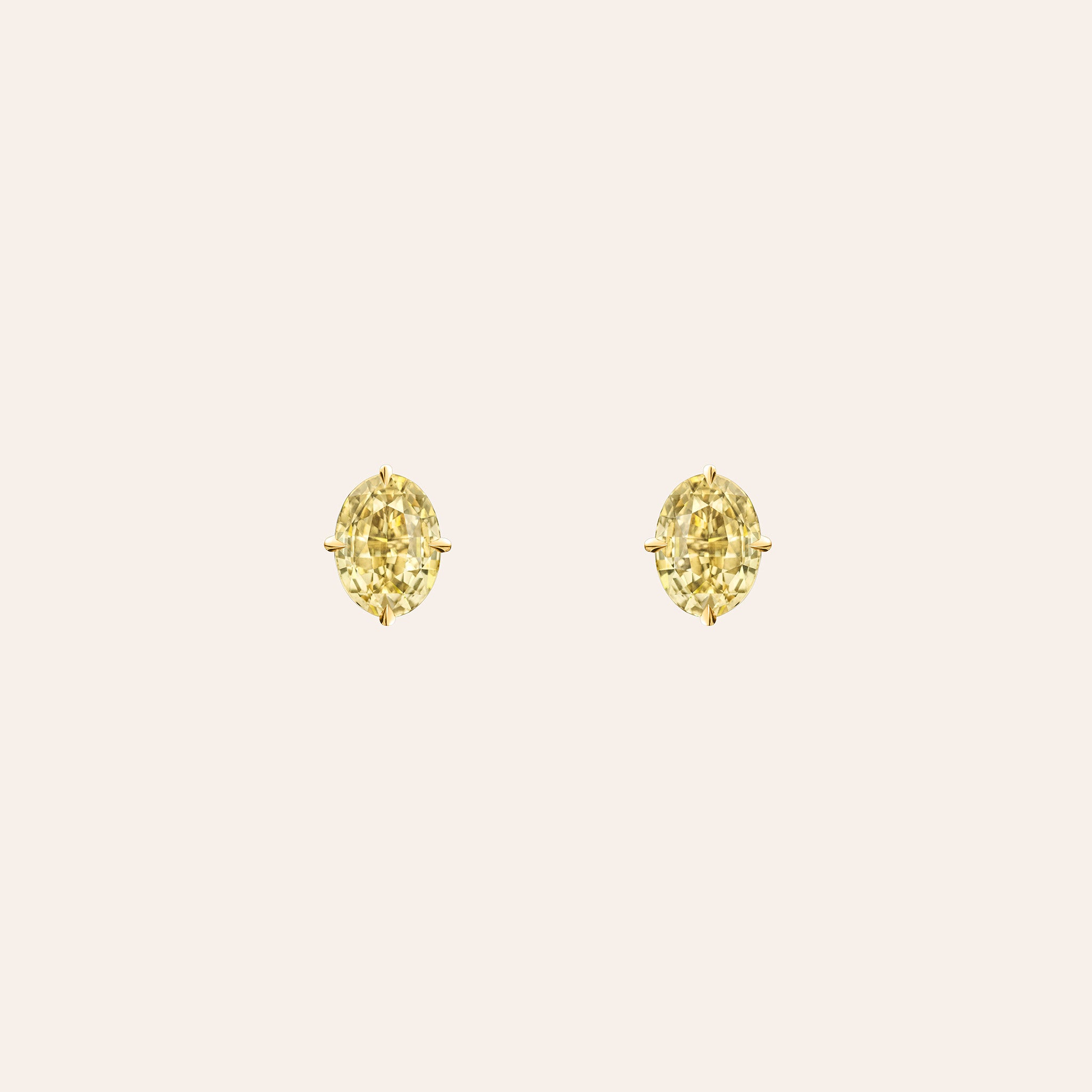 The Sloane Yellow Sapphire Oval Studs in 18K yellow gold, with oval-cut yellow sapphires, shown against a cream background.
