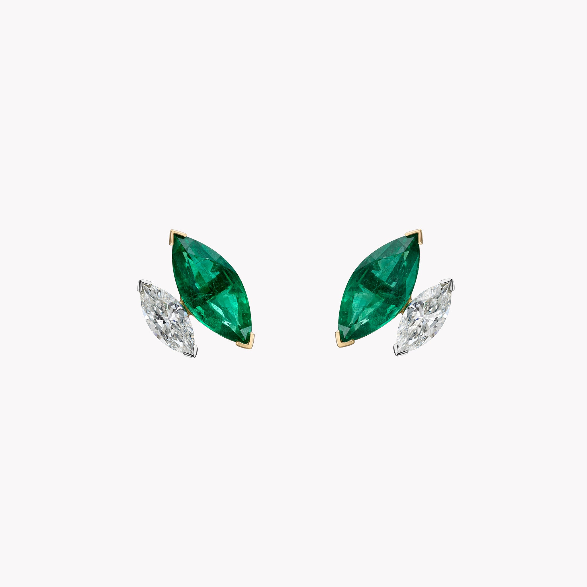 Marquise emerald and diamond stud earrings in 18K yellow and white gold shown in slanted position