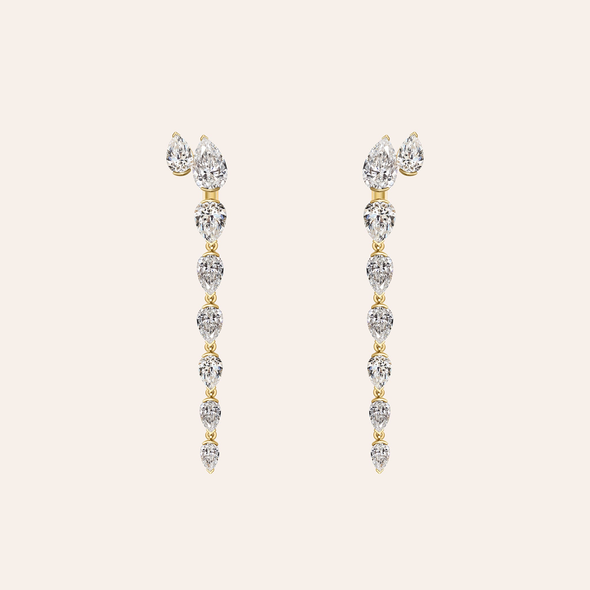 The Aryna Earring Jackets attached to pear diamond studs, forming a graduated pear diamond drop in 18K yellow gold