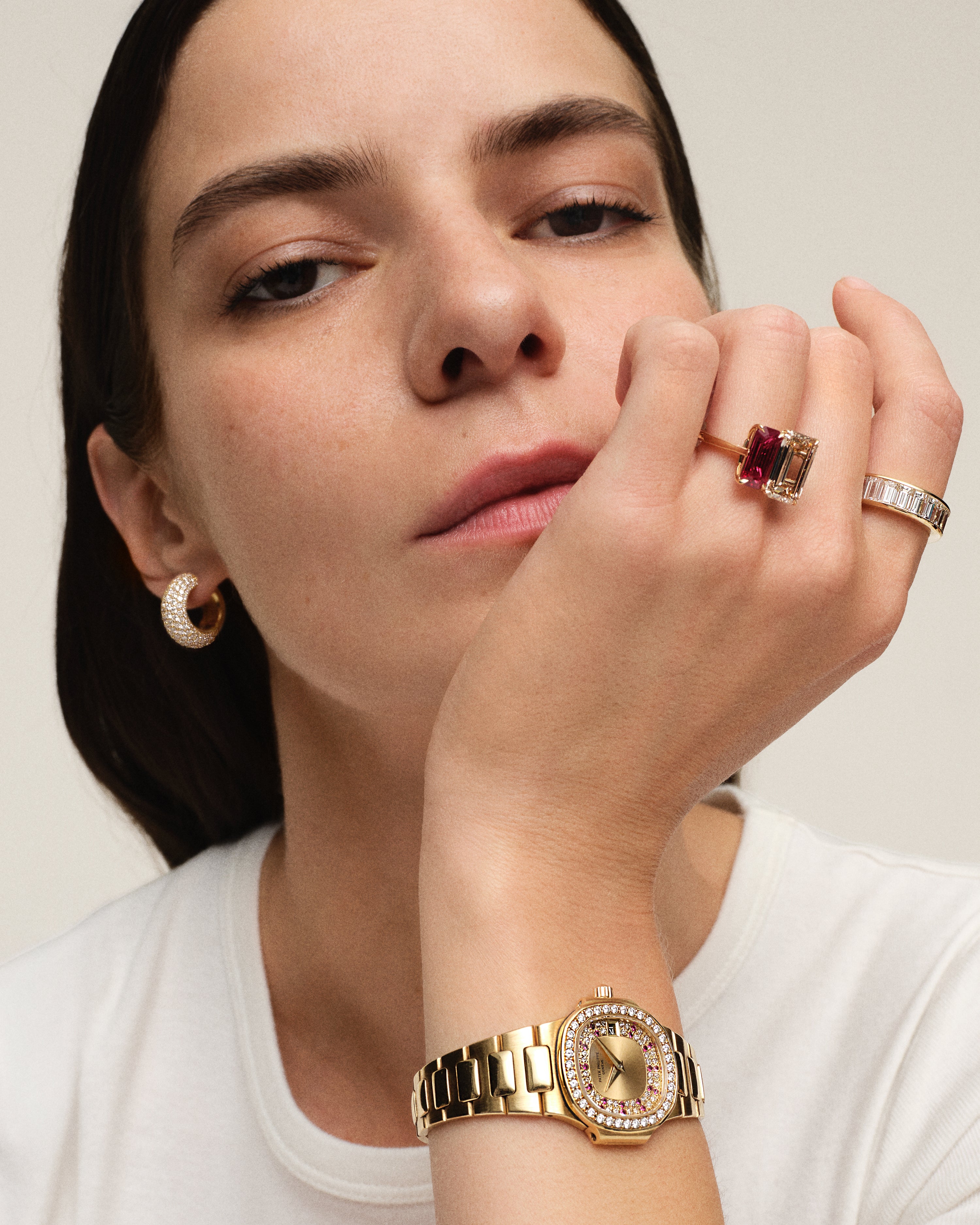 A1: Front view of an 18K yellow gold two-stone ring featuring a 4.01ct fancy yellow-brown emerald-cut diamond alongside a 2.56ct red ruby emerald cut, set in a toi et moi configuration with double corner prongs. on model