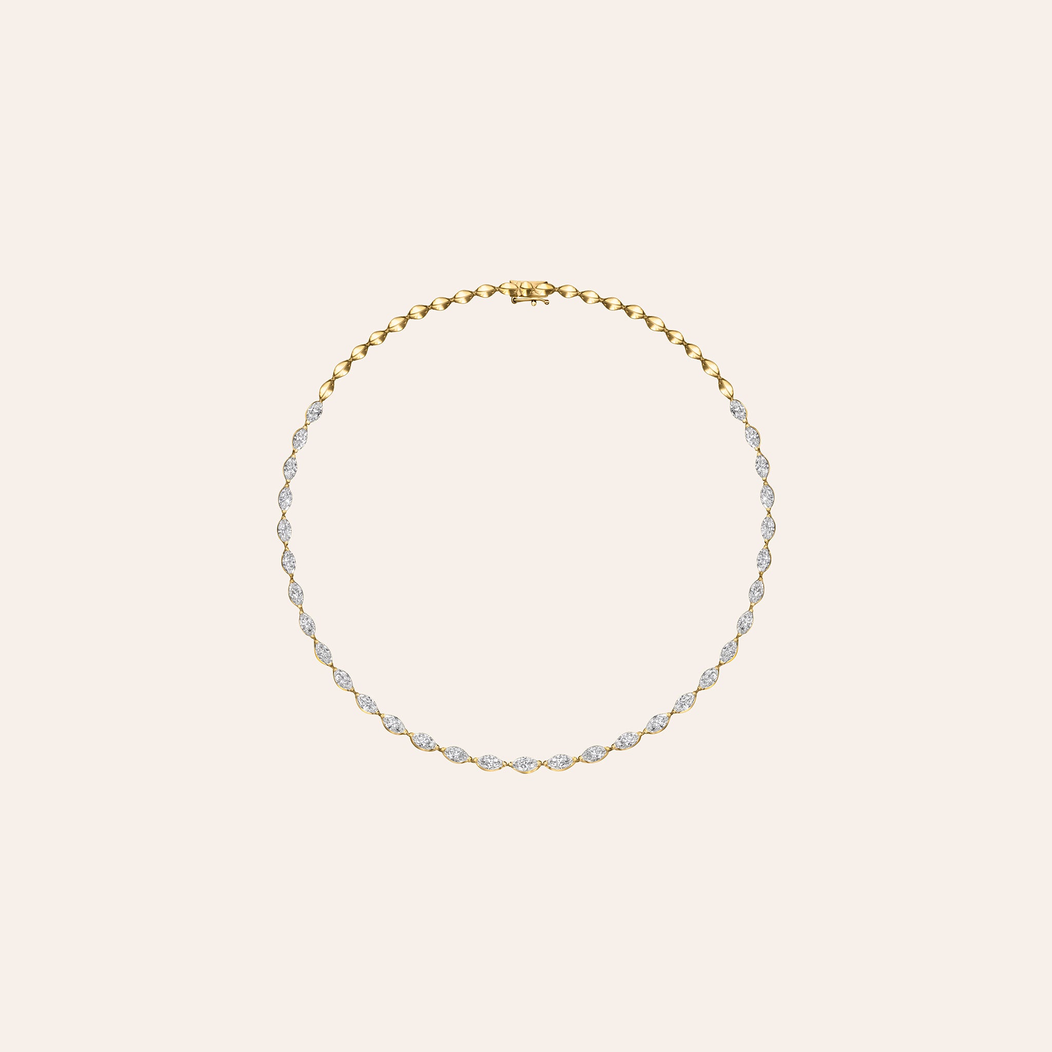 A delicate gold chain necklace with small clear stones set along the front, displayed on a solid pale cream background.