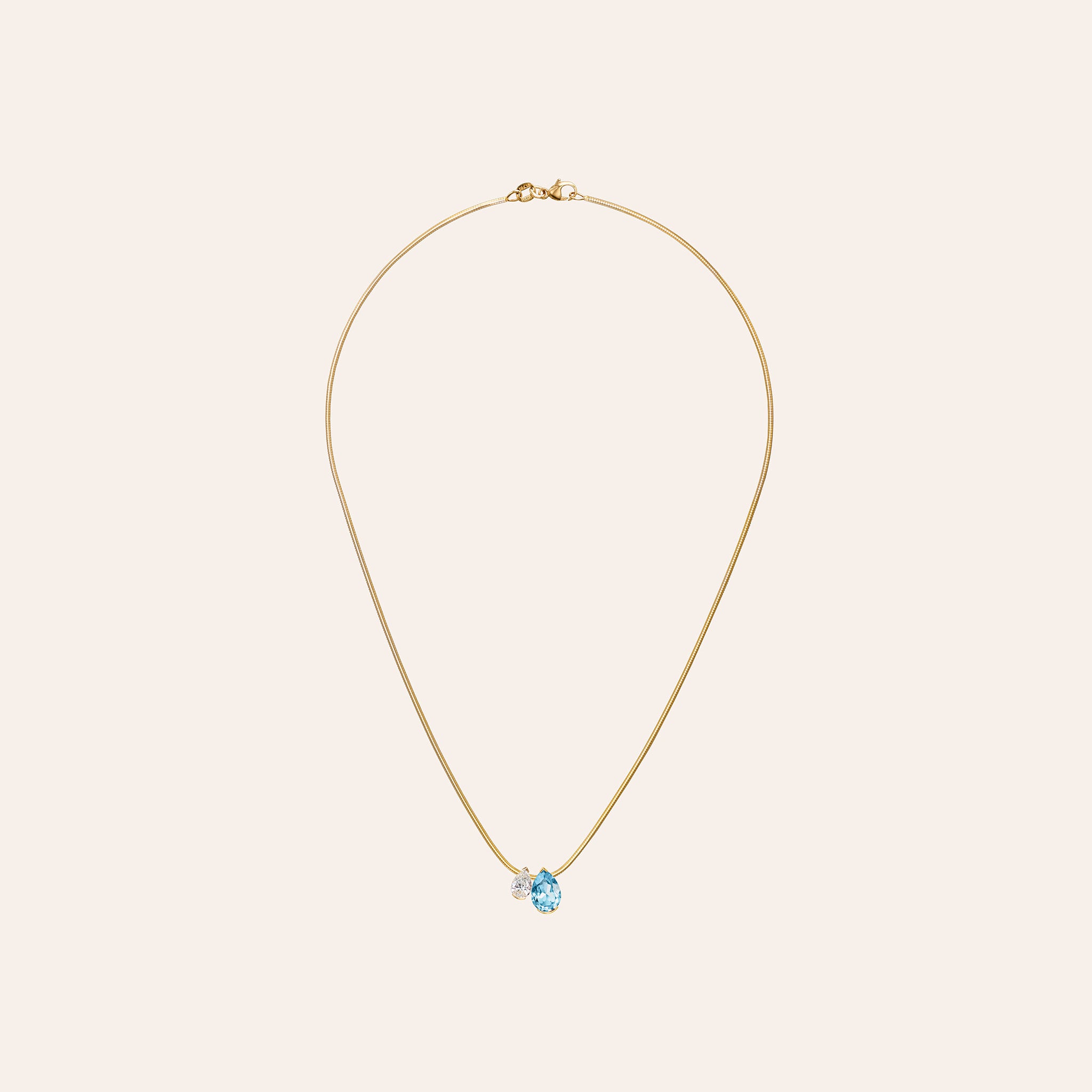 The Aquamarine Muse Duo Pendant with a pear aquamarine and pear diamond on an 18k yellow gold snake chain
