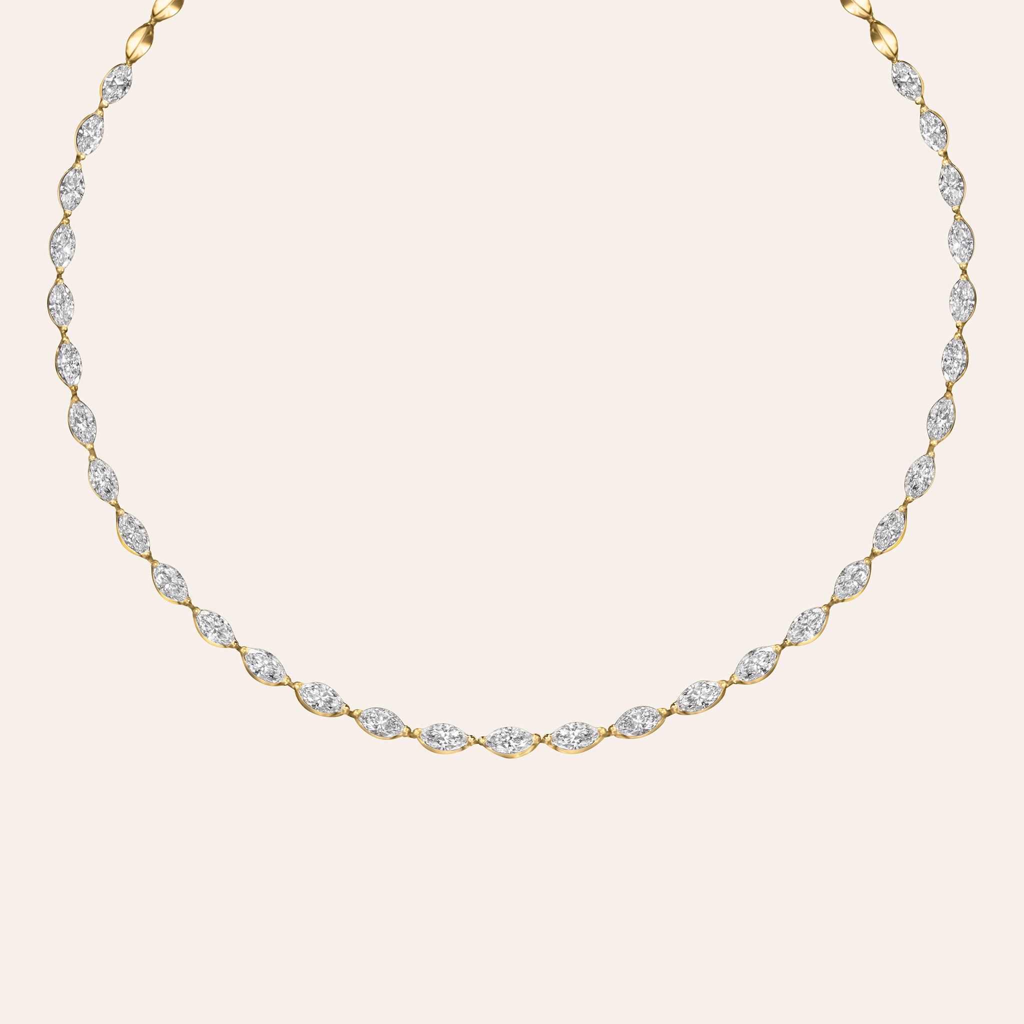 A delicate yellow gold necklace featuring a continuous line of small marquise-cut clear stones, displayed against a solid light beige background.