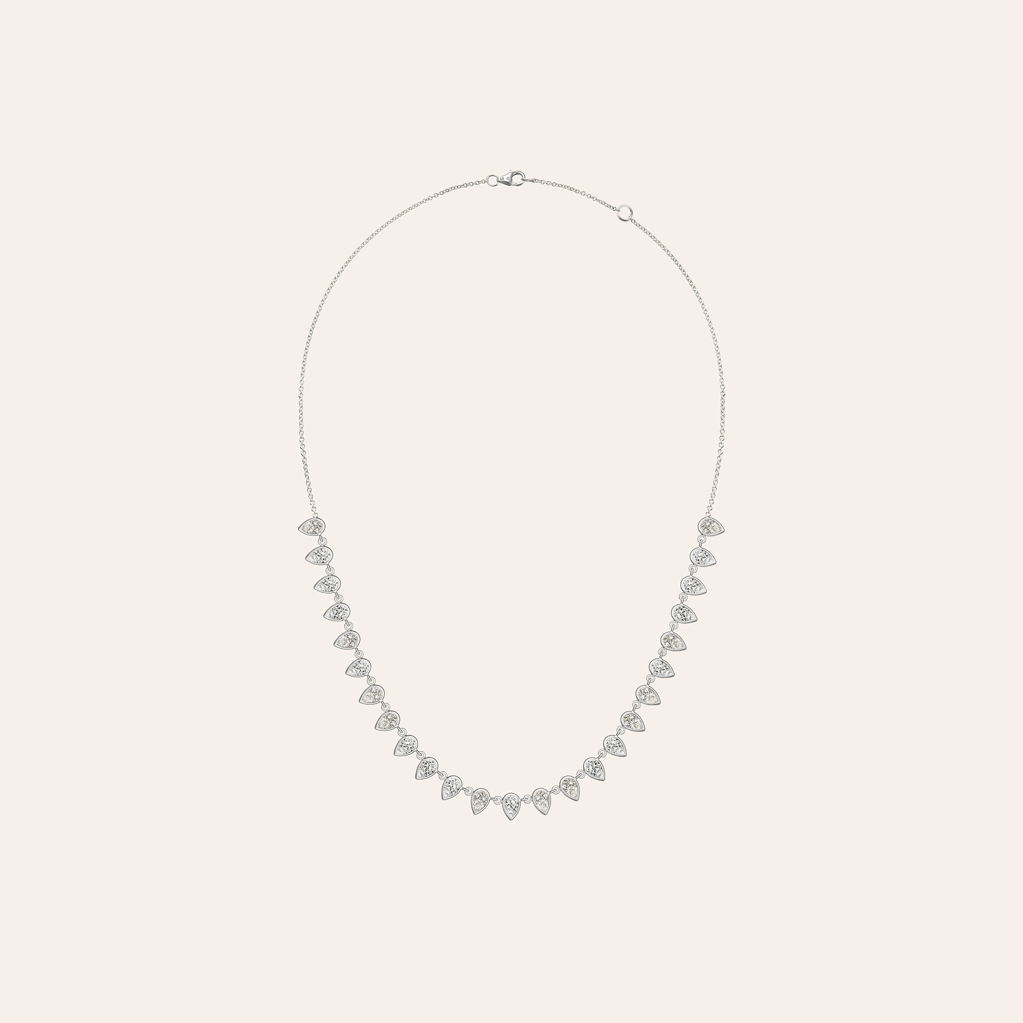 Alternate view of The Lena Pear Shape Necklace in 18K white gold, showing bezel-set pear-shaped diamonds in a fringe, against a cream background.