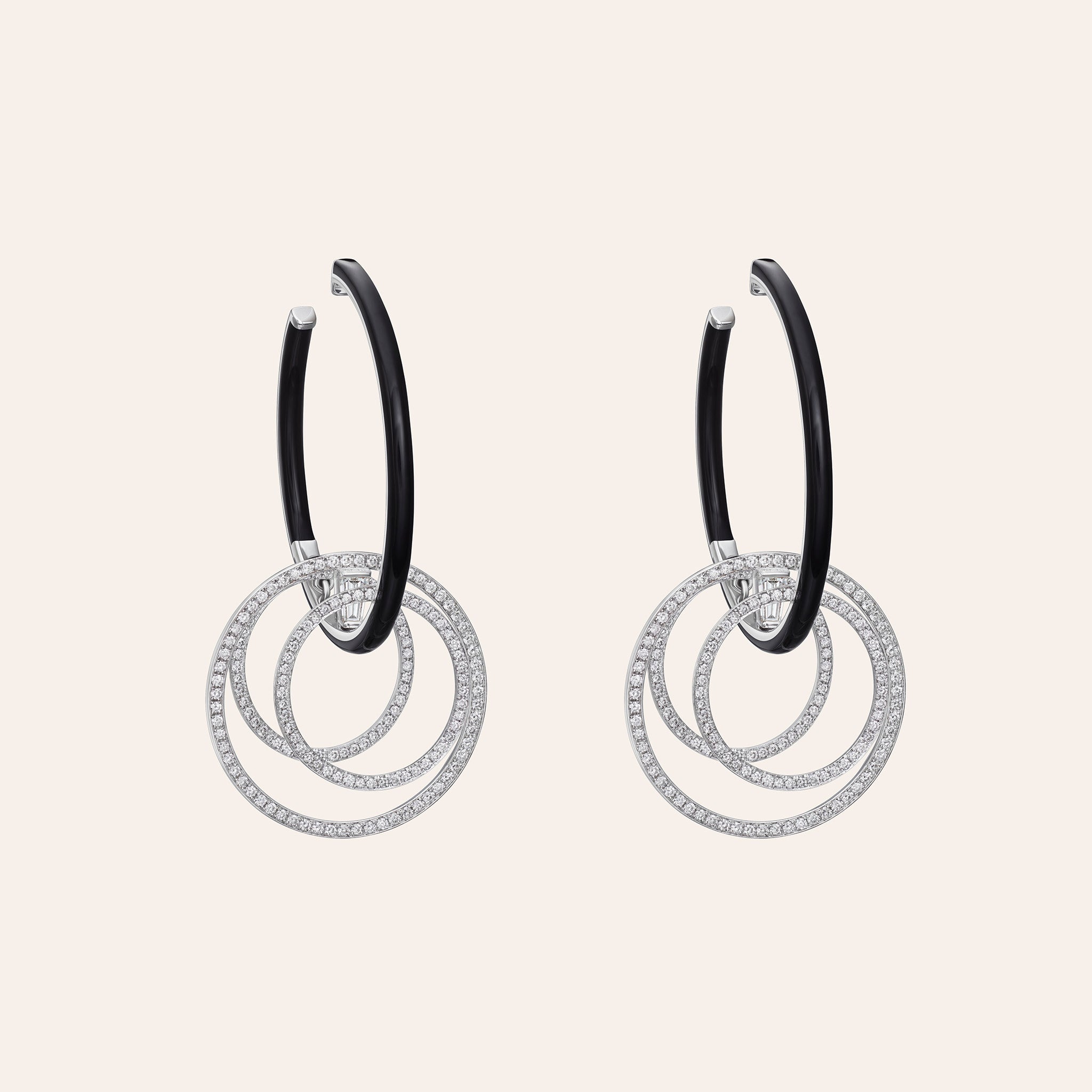 Nikos Koulis Oui Diamond & Black Enamel Hoops in 18K white gold, with baguette and round brilliant diamonds set with black enamel, shown against a cream background.