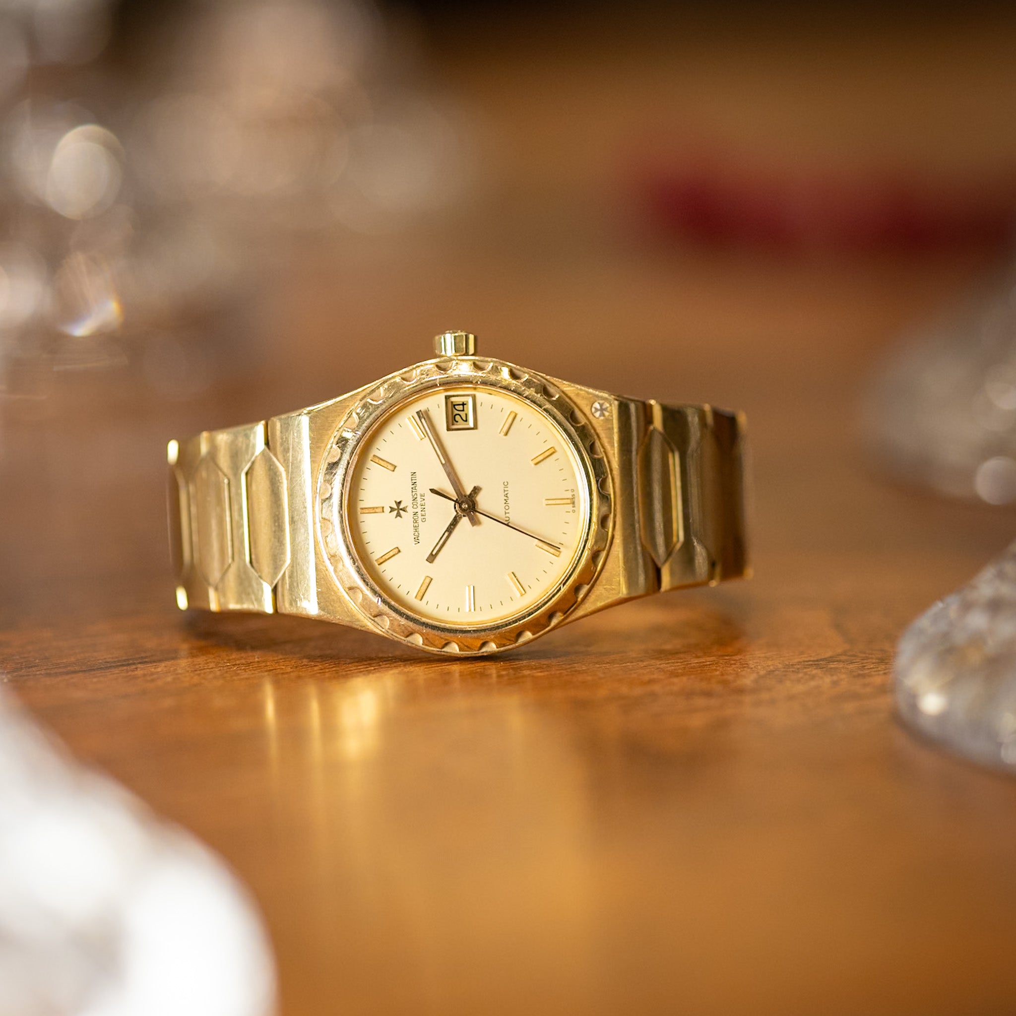 Gold wristwatch on a wooden surface with blurred background