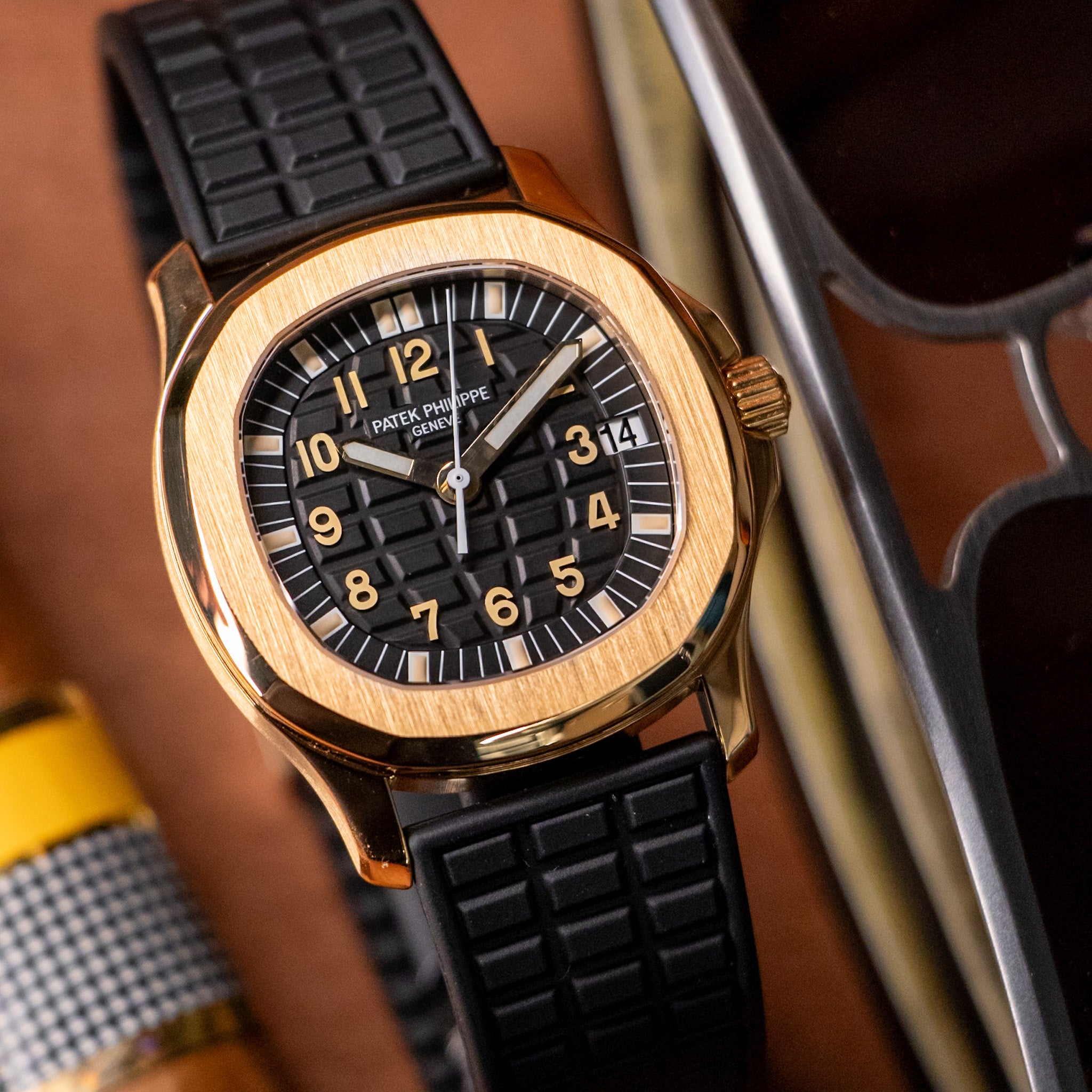 Luxury watch with black dial and gold case on a blurred background