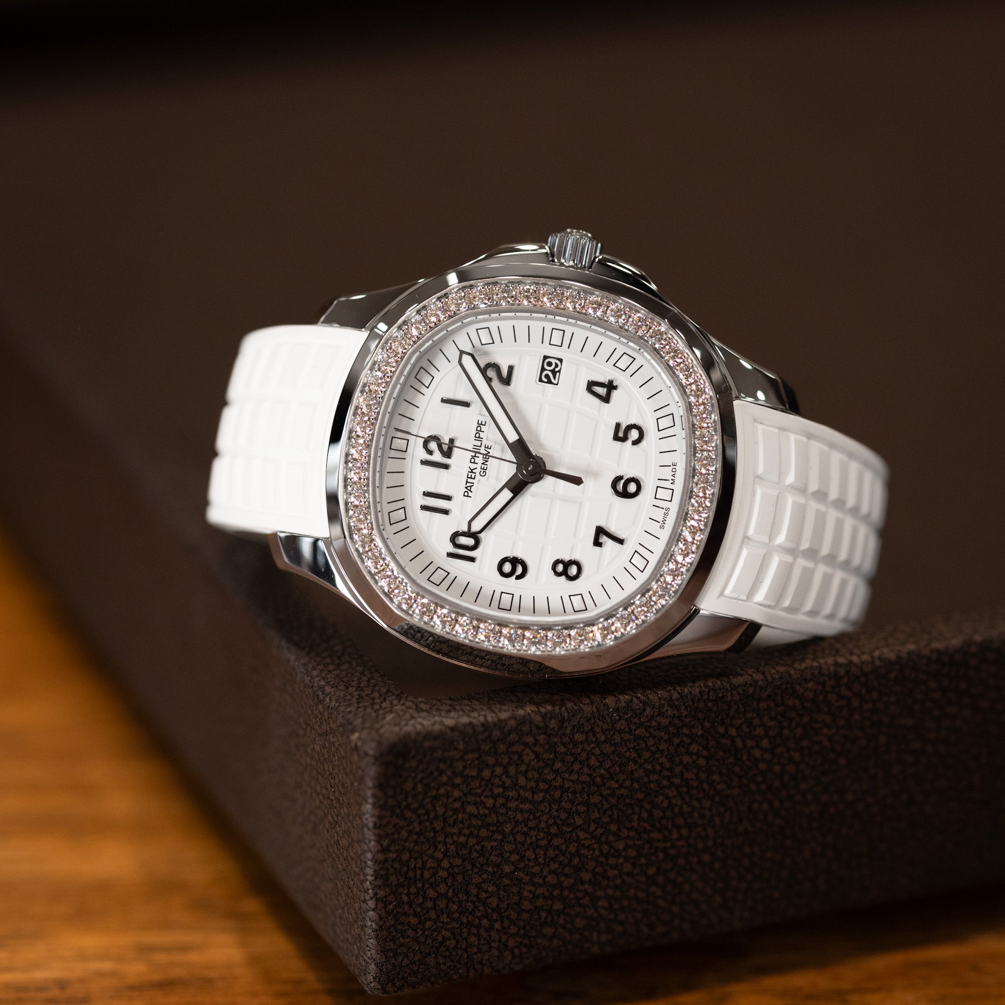 White watch with a decorative band on a brown surface