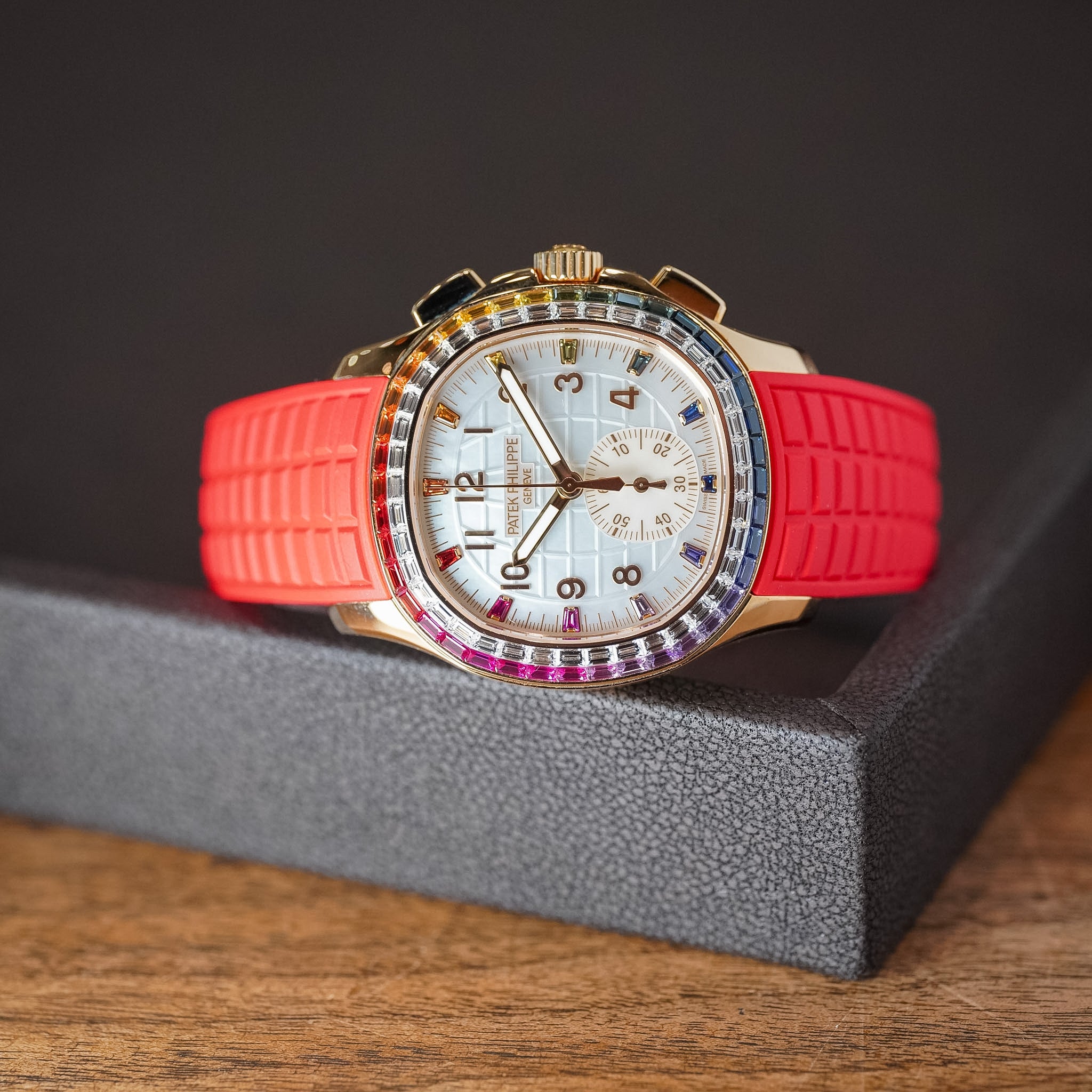 Wristwatch with a red strap and gold case on a dark background