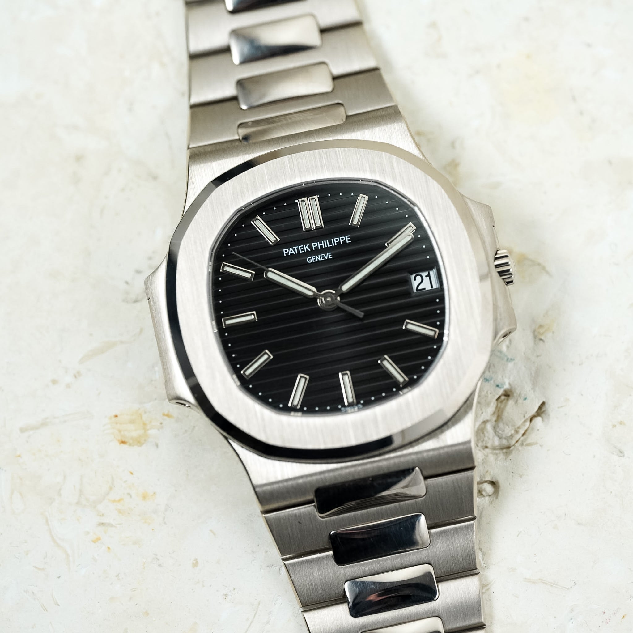 Silver Patek Philippe watch on a white marble surface
