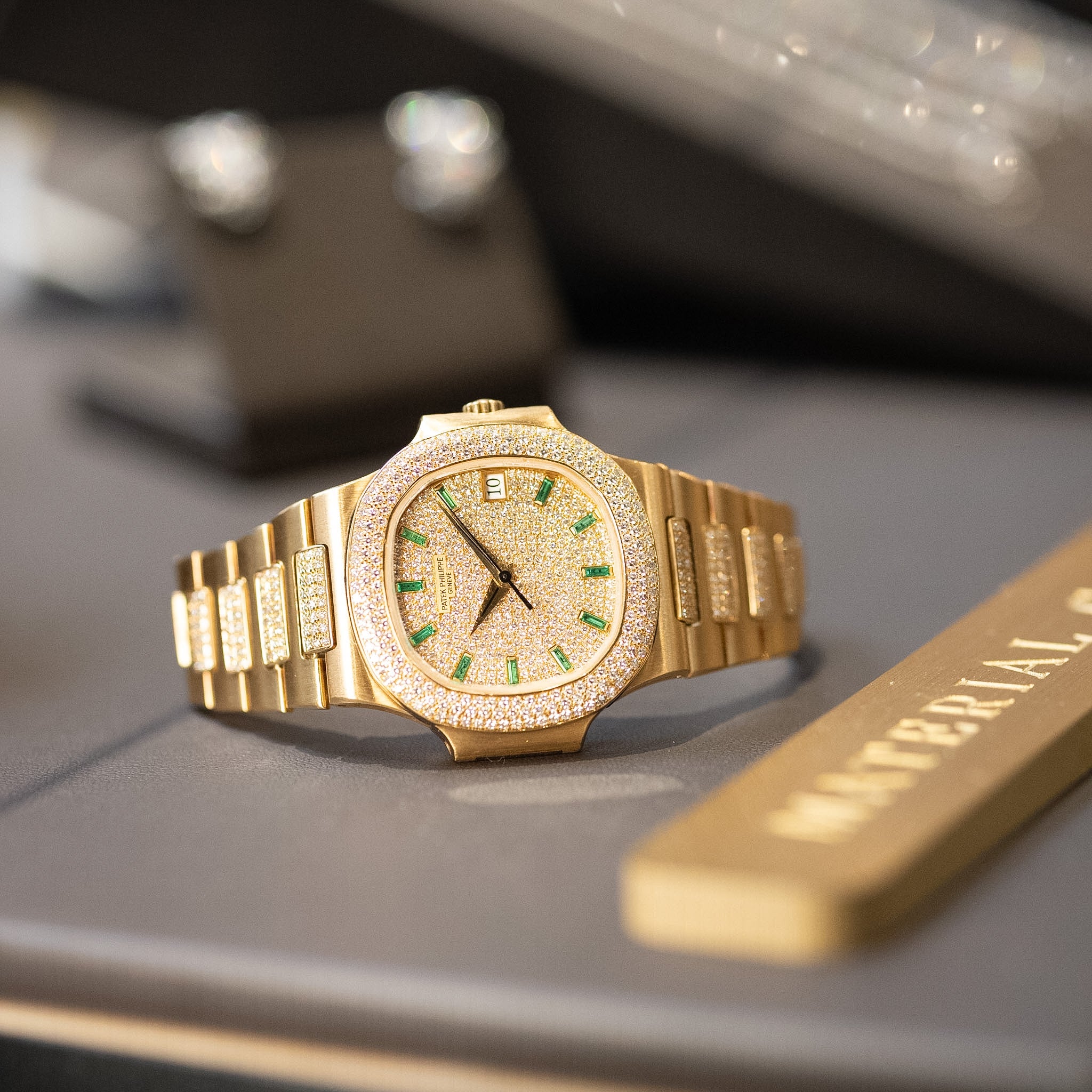 Gold watch with diamond accents on a gray surface