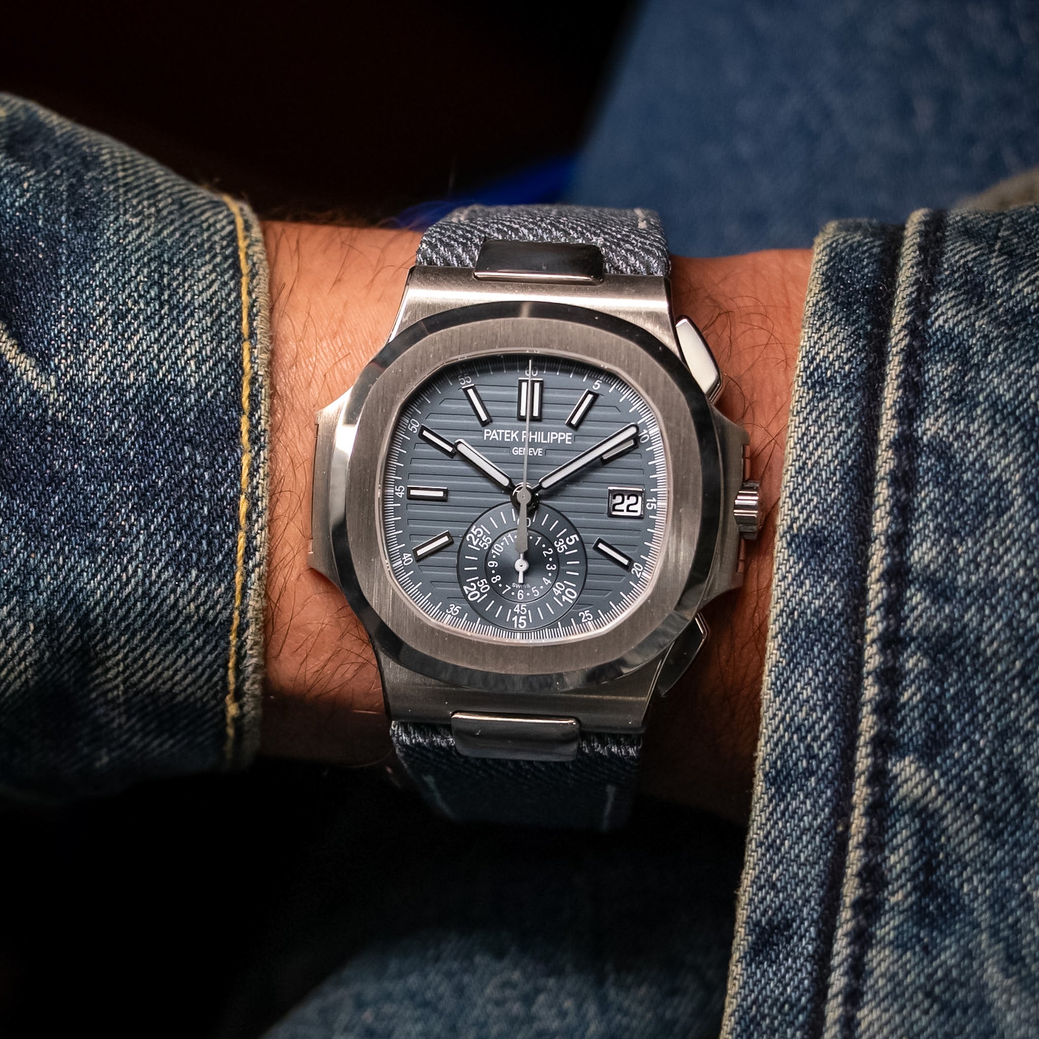 Luxury watch on a person's wrist with denim background