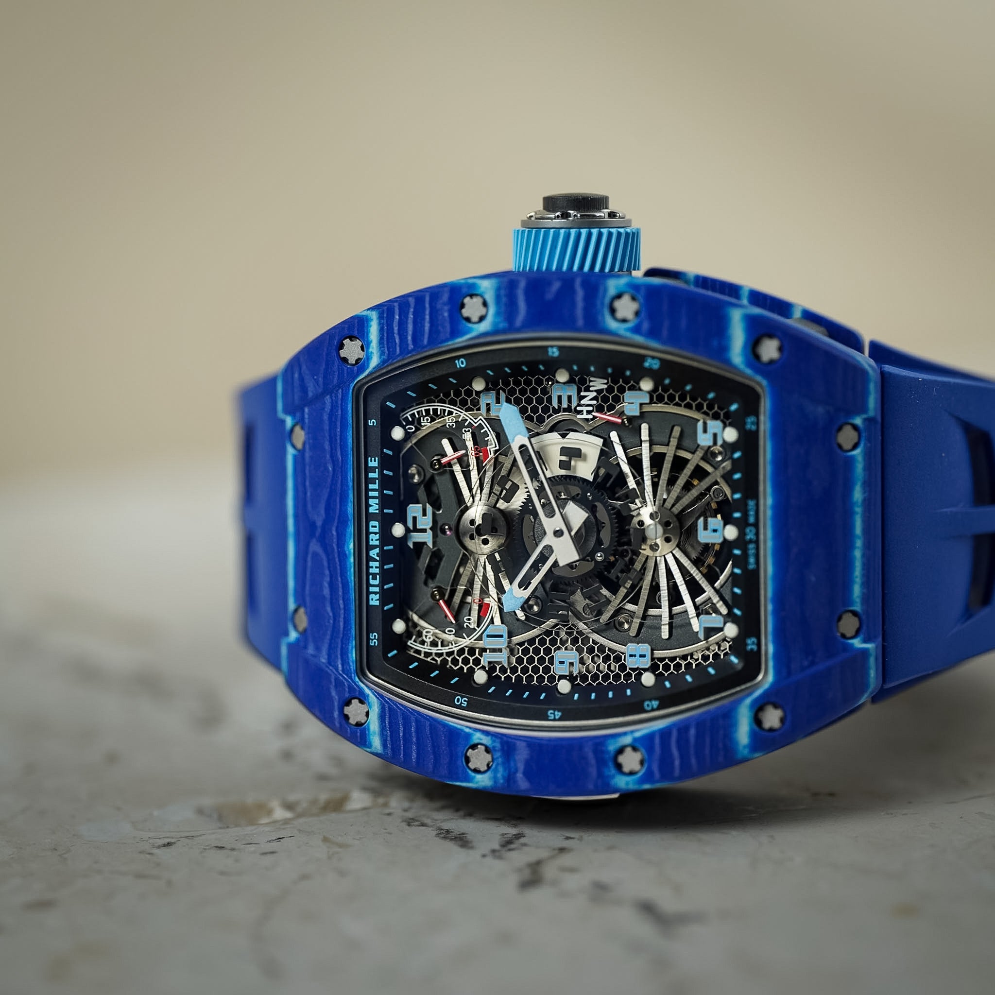 Blue luxury watch laying on its side on a marble table