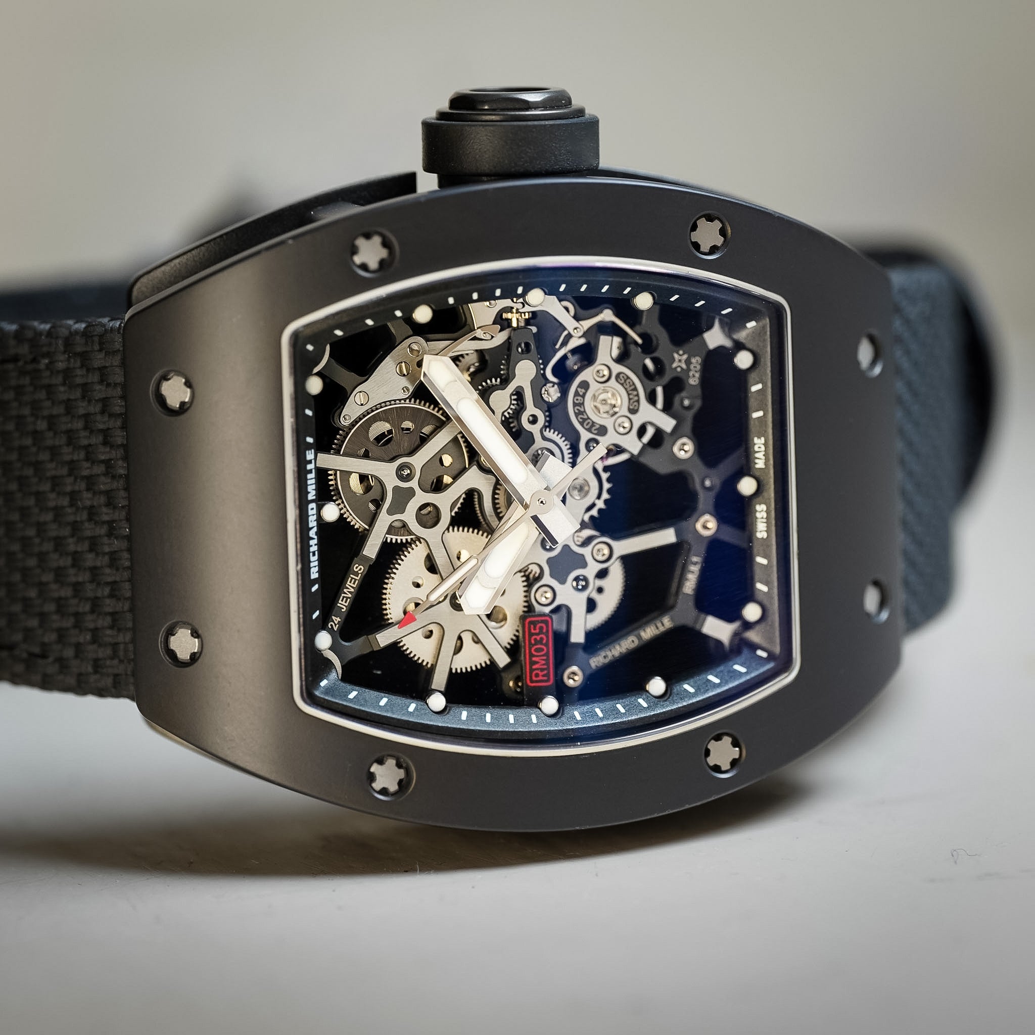 Black sport watch with a skeleton dial laying on its side