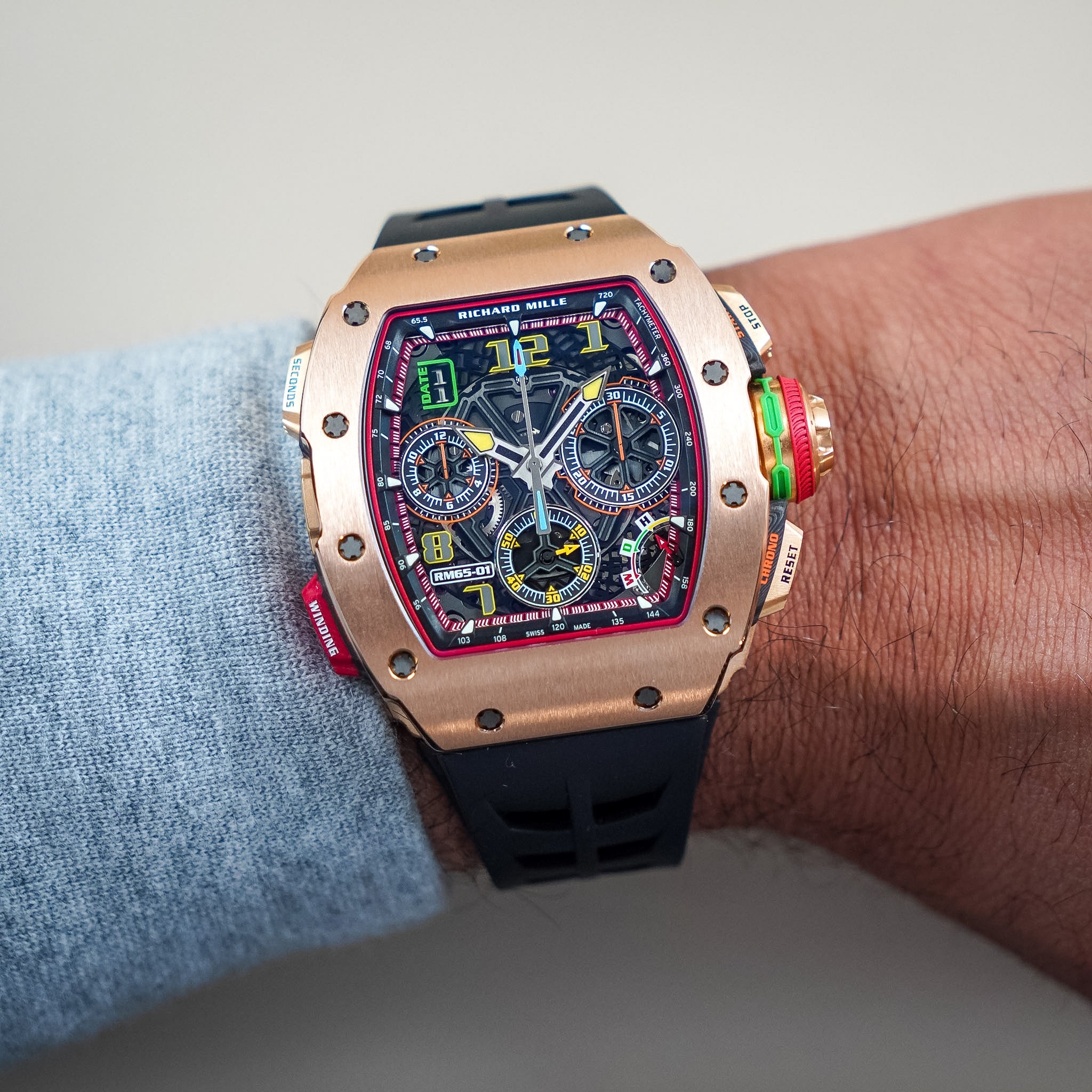 Luxury watch with a detailed face on a person's wrist against a neutral background