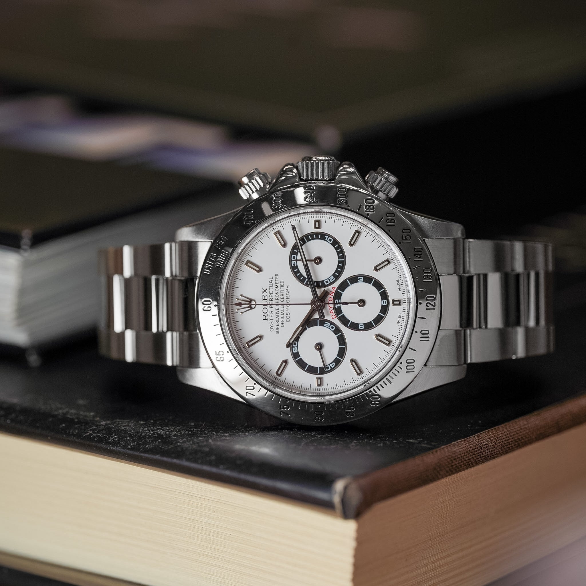 Silver watch with a white face on a book