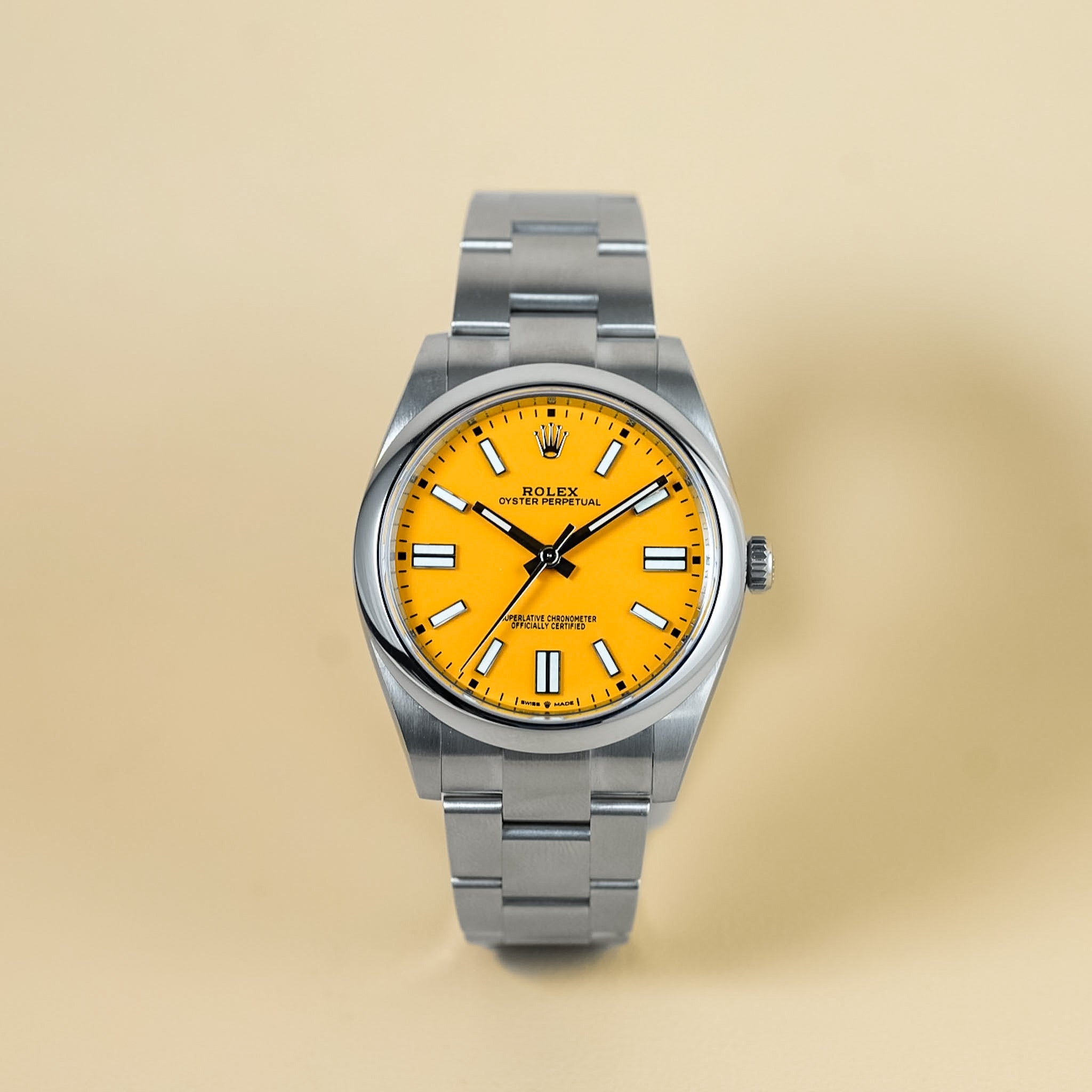 Silver watch with a yellow face on a beige background