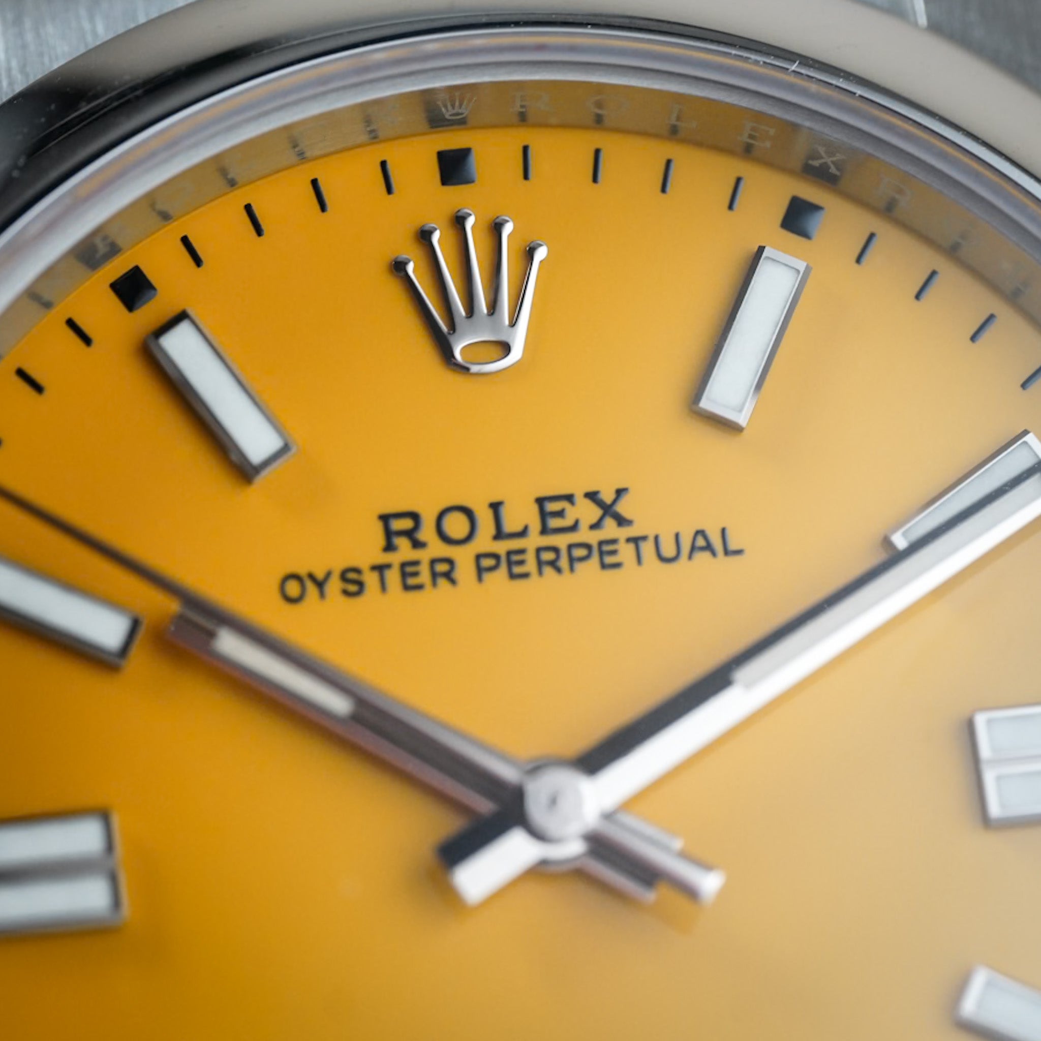 Close-up of a Rolex Oyster Perpetual watch with a yellow face.