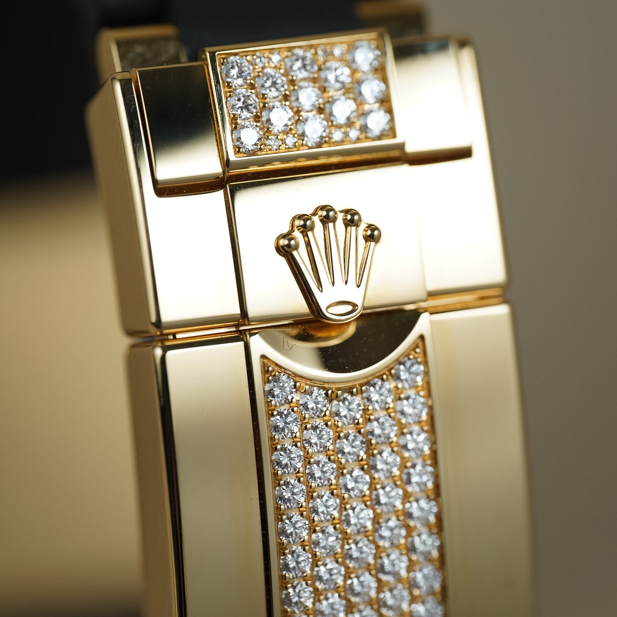 Gold watch case with diamond-studded face and Rolex logo