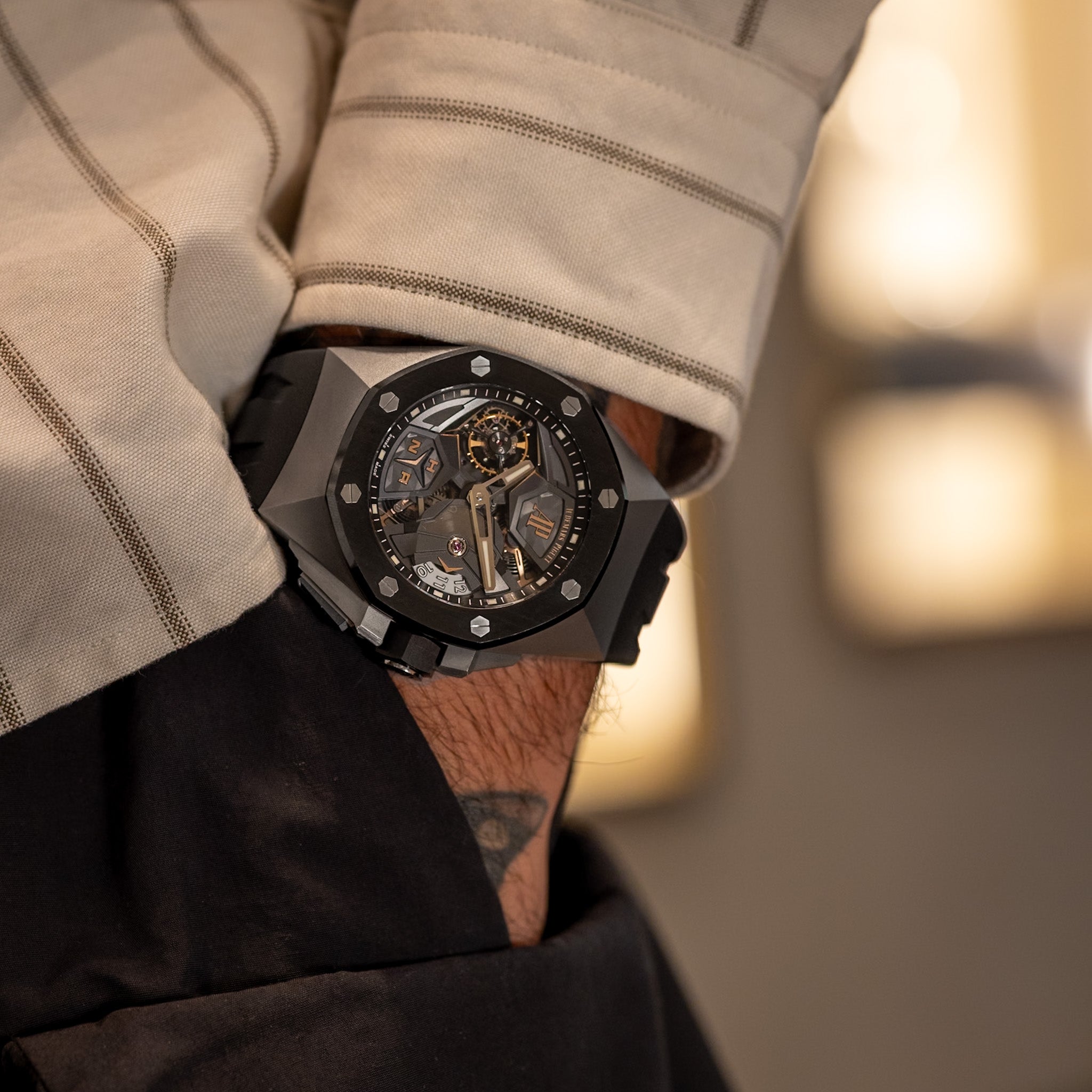 Close-up of a person wearing a black wristwatch with a textured face.