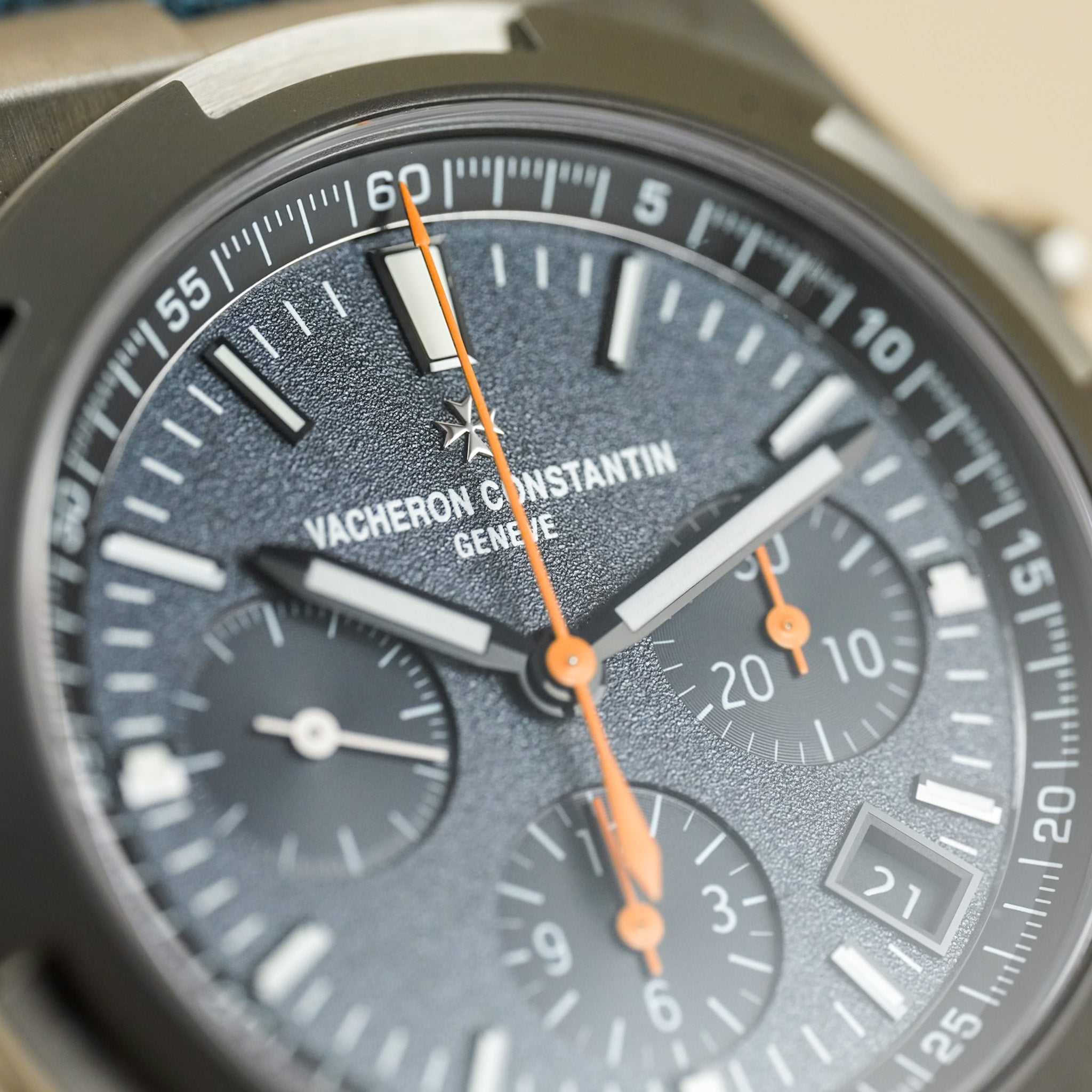 Close-up of a Vacheron Constantin watch face with orange hands.