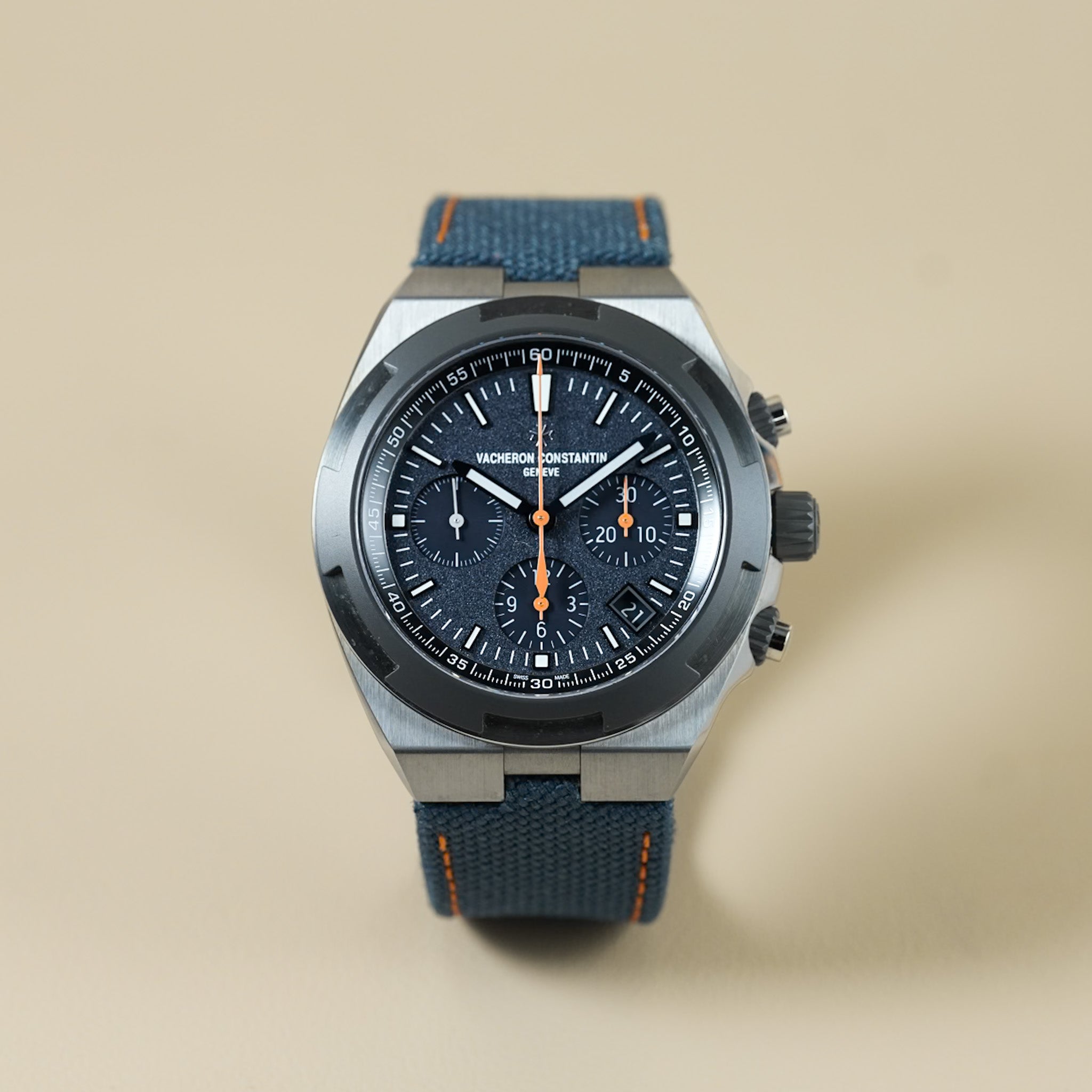 Wristwatch with blue strap and dark face on beige background