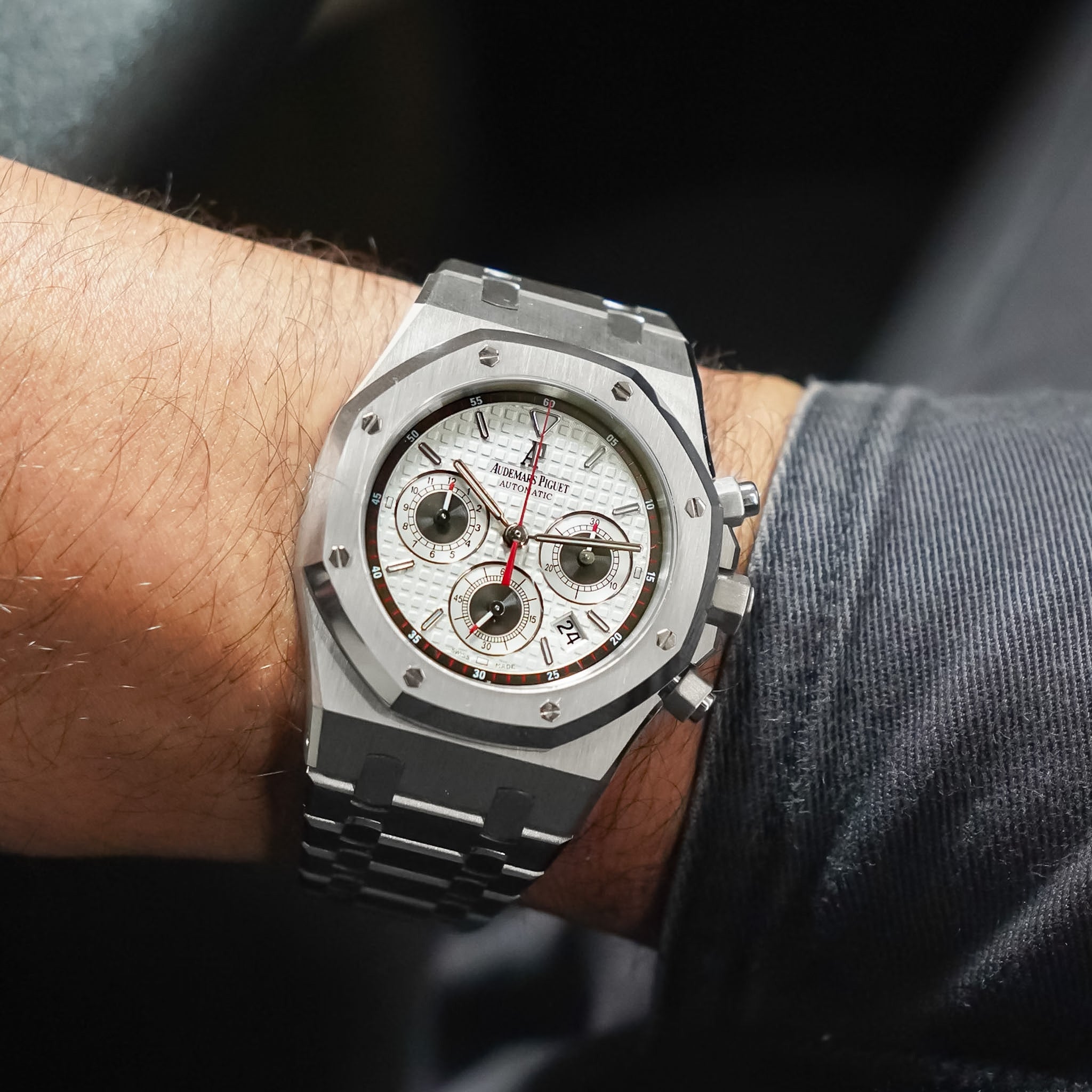 Luxury watch on a person's wrist with a dark background